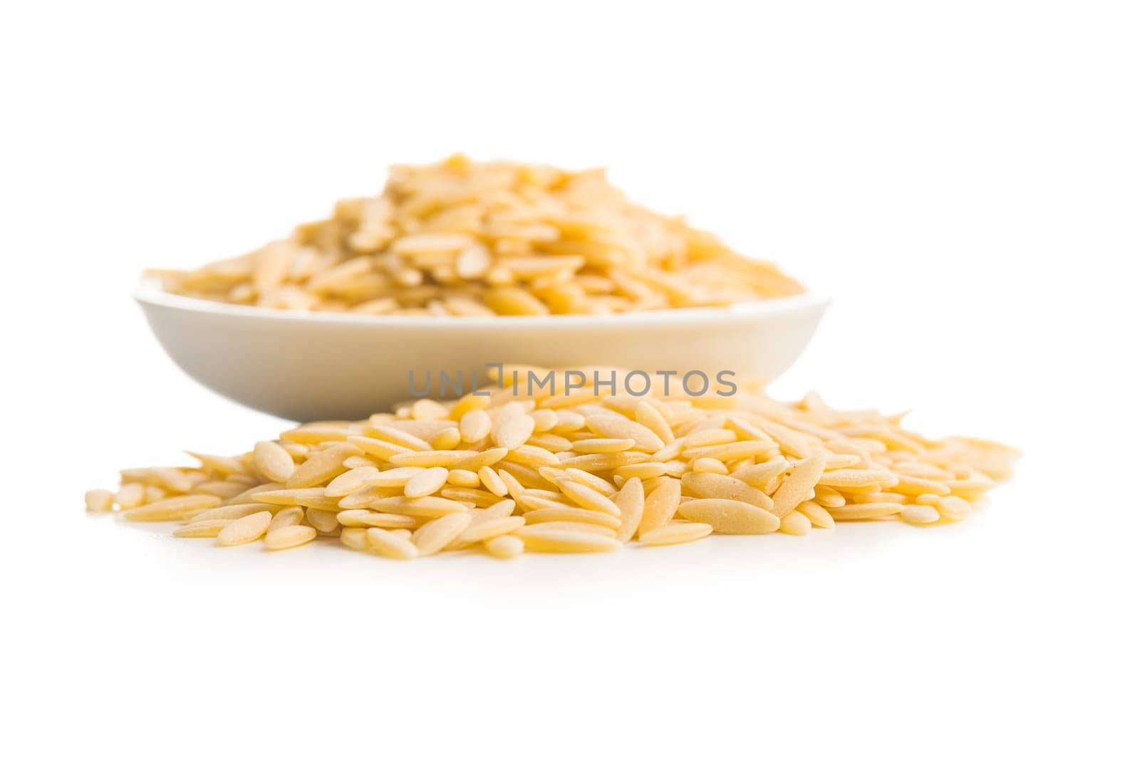 Orzo, kritharaki, risoni pasta. Uncooked dry pasta in bowl isolated on a white background.