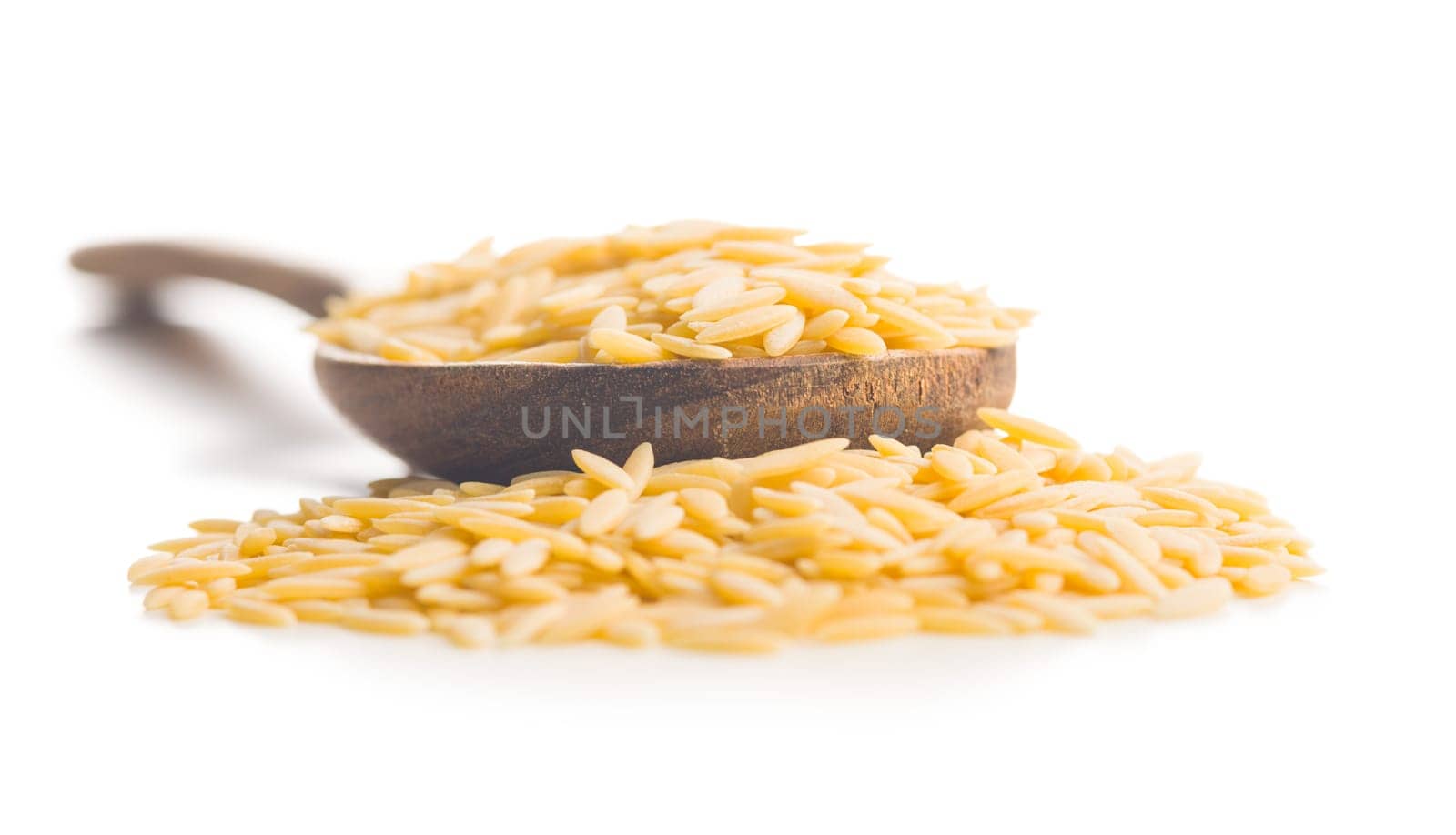 Orzo, kritharaki, risoni pasta. Uncooked dry pasta in spoon  isolated on a white background.