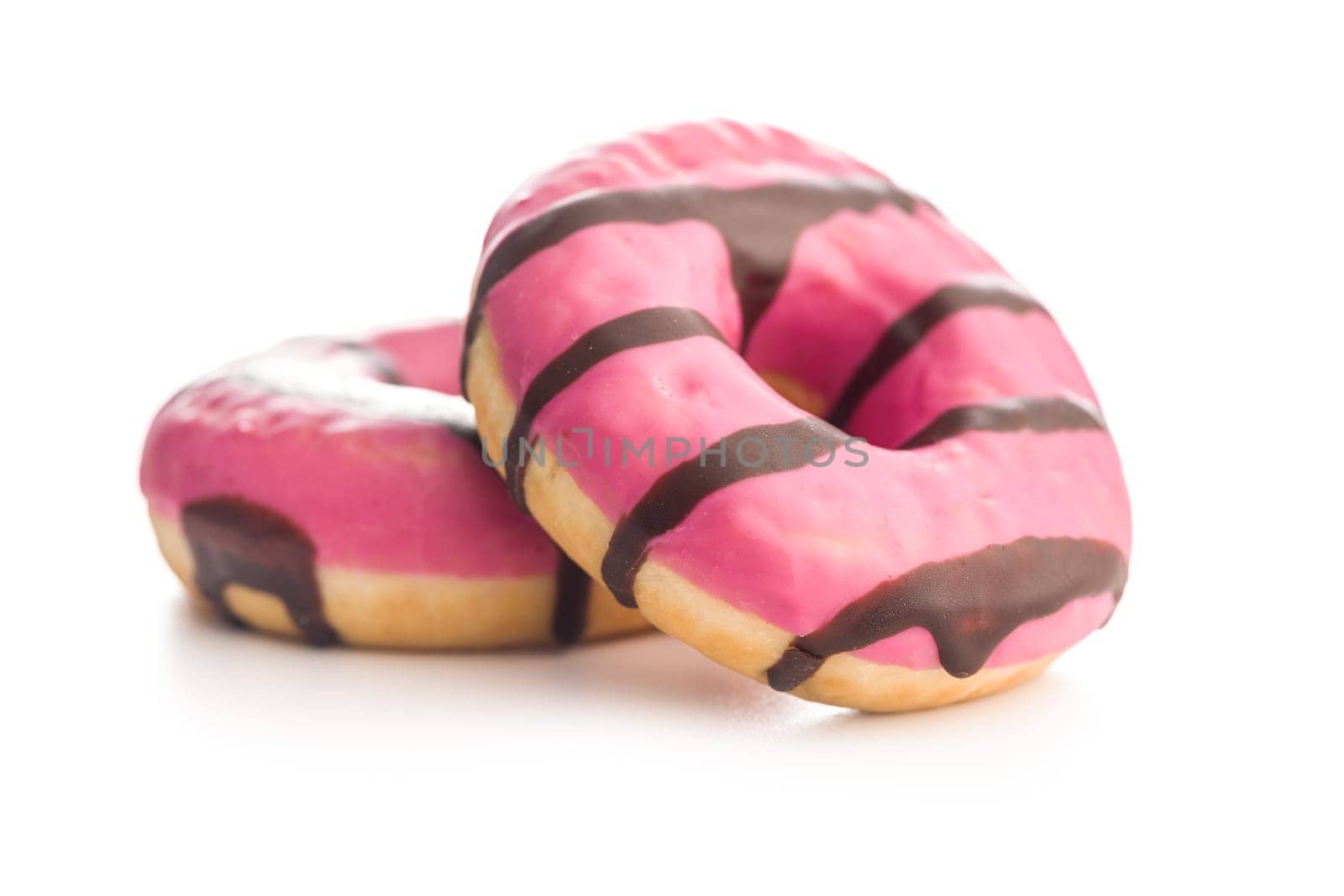 Sweet pink donut with chocolate strips isolated on a white background.