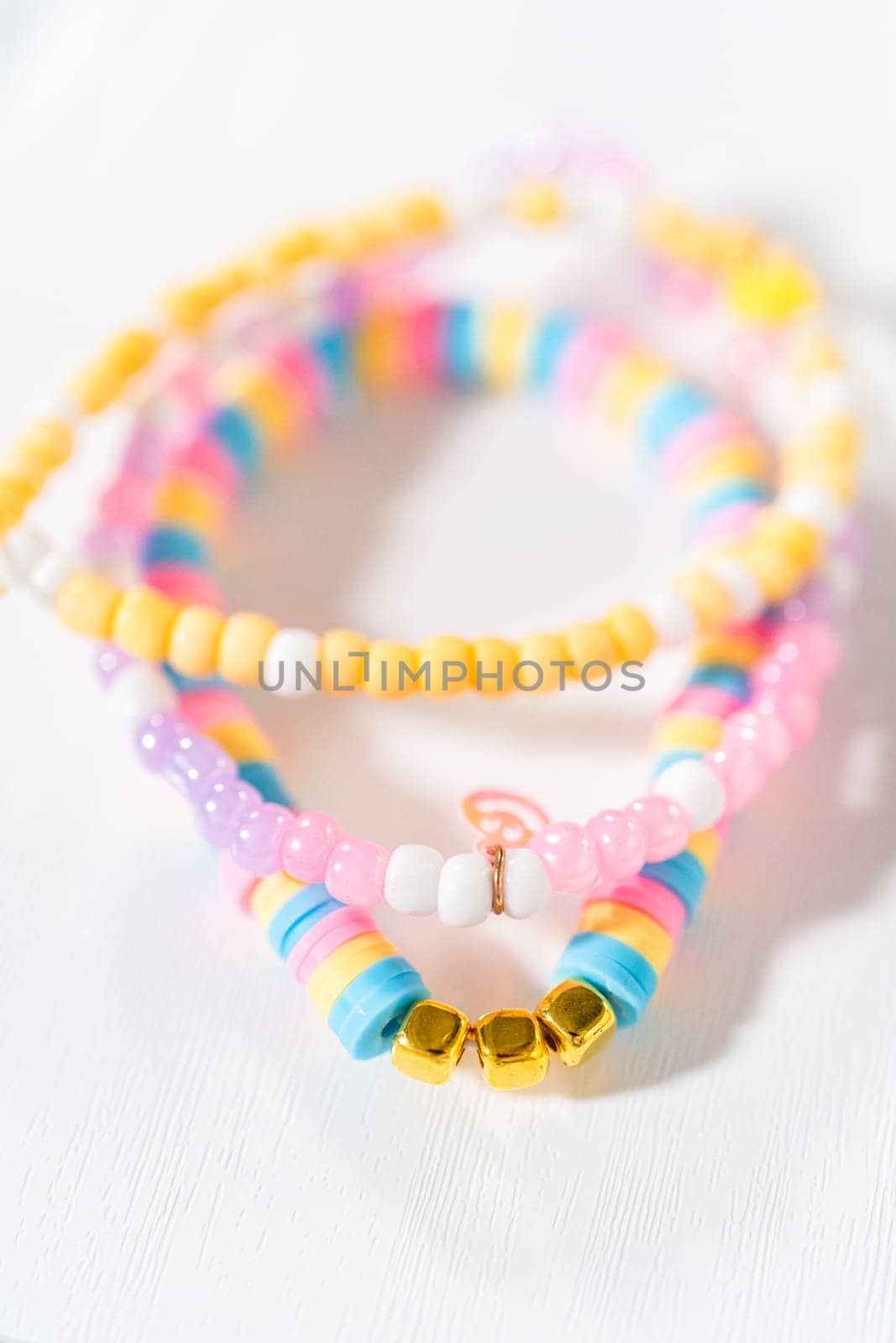 Little girl's charming bracelets adorned with clay and sea beads.