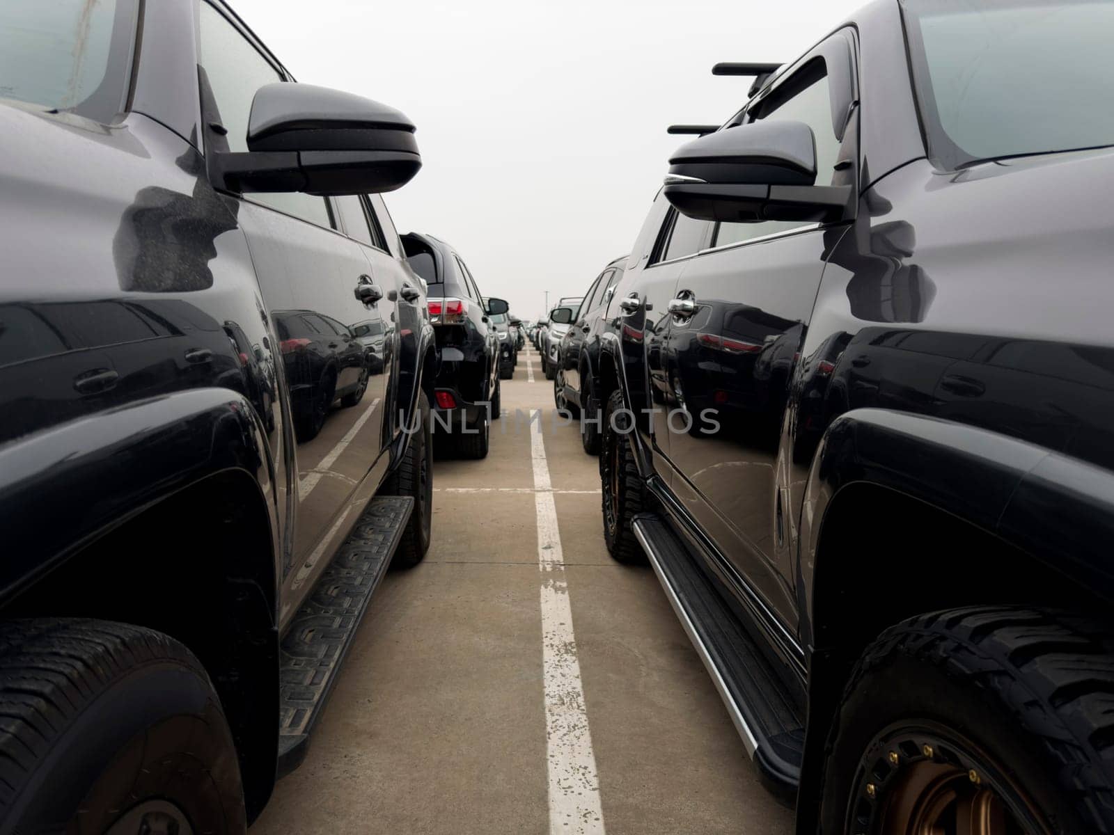 Endless row of cars for sale in street parking lot. Auto shop on street for convenient selection of cars in large parking lot. Selecting and purchasing new car from large assortment