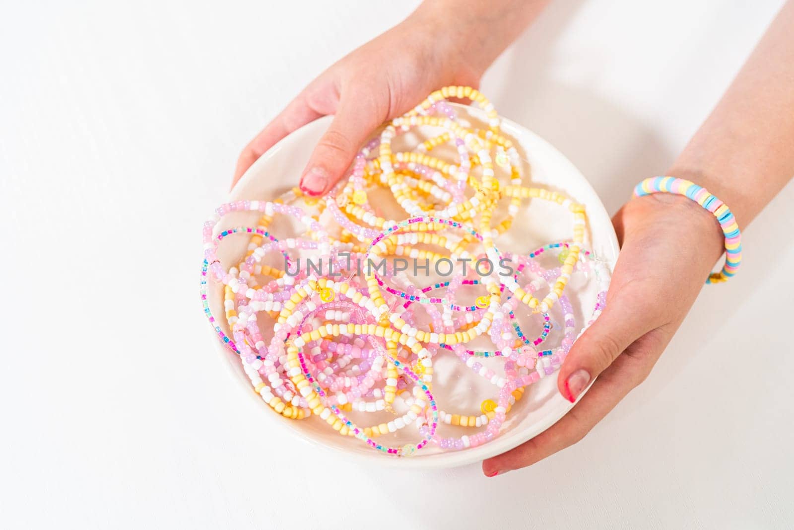 Little girl's charming bracelets adorned with clay and sea beads.