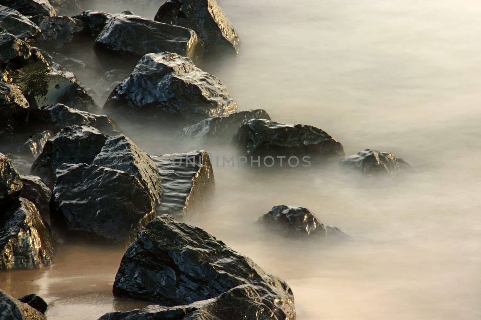 Shore fortification lapped by waves. Long exposure with neutral density filter