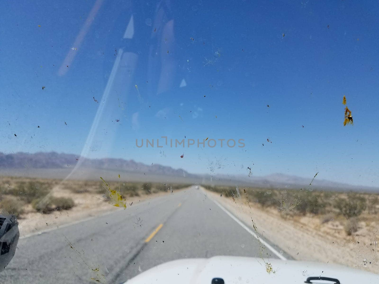 Looking Out through a Dirty Windshield on a Two Lane Desert Highway. High quality photo