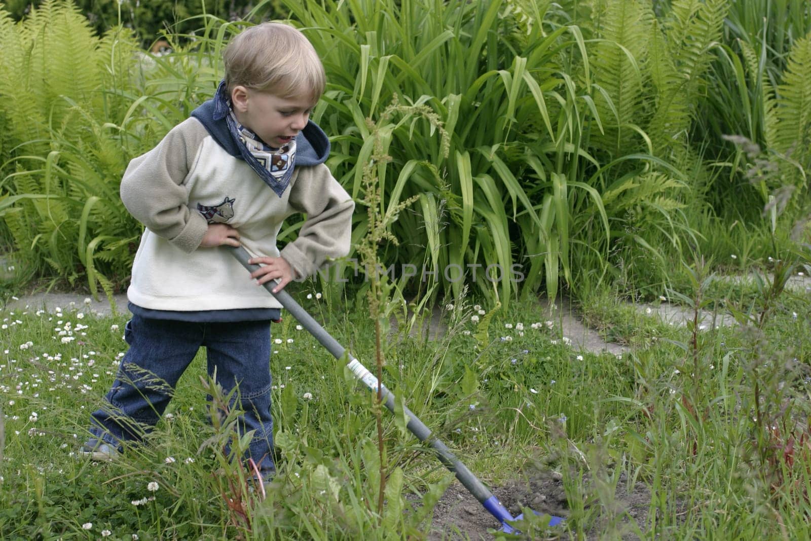 Boy playing in the garden with a shovel