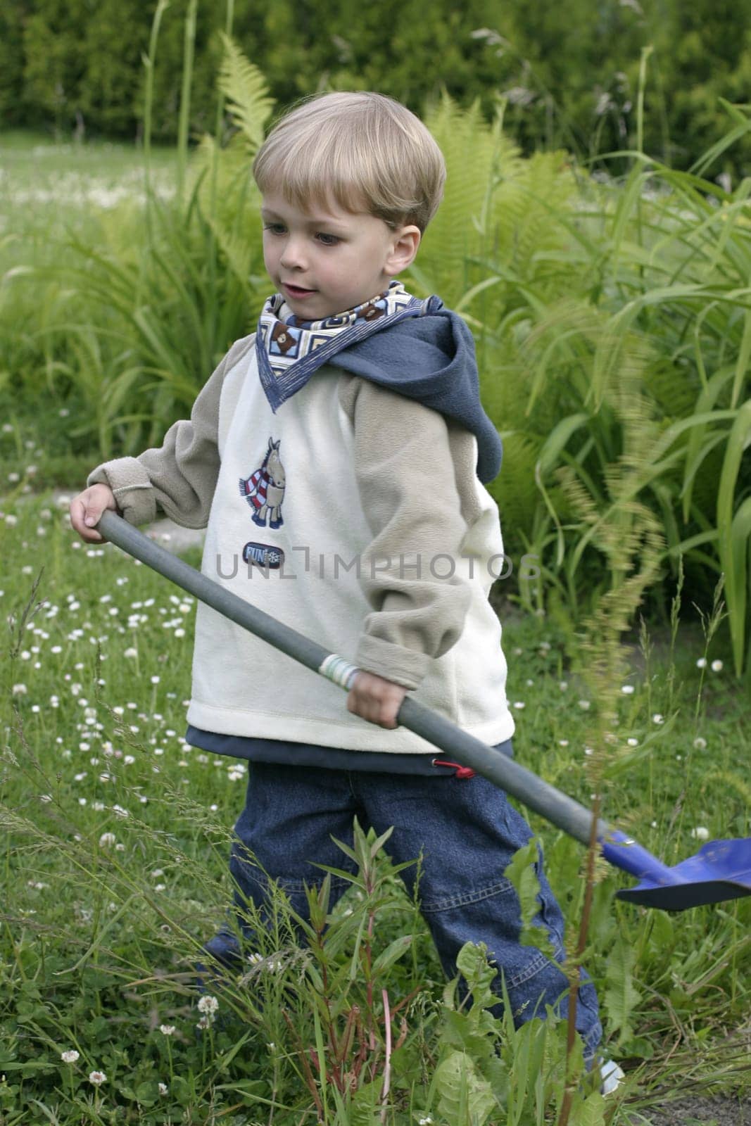 Boy playing in the garden with a shovel