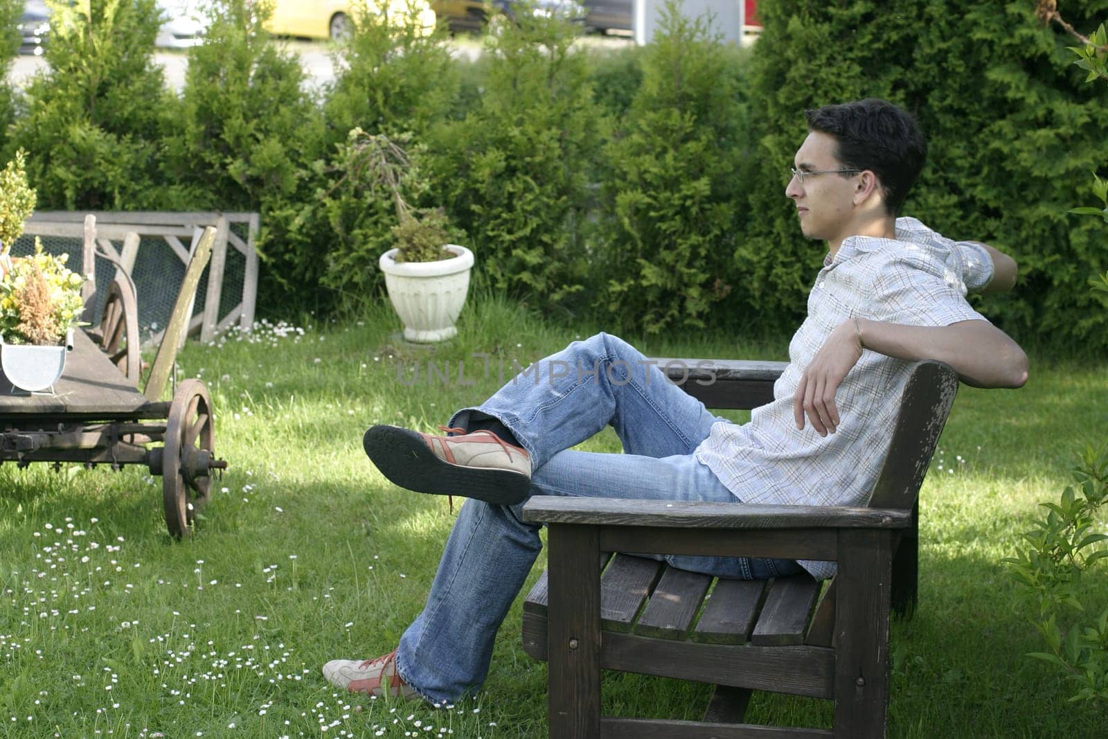 Father sits on a bench and watches his son