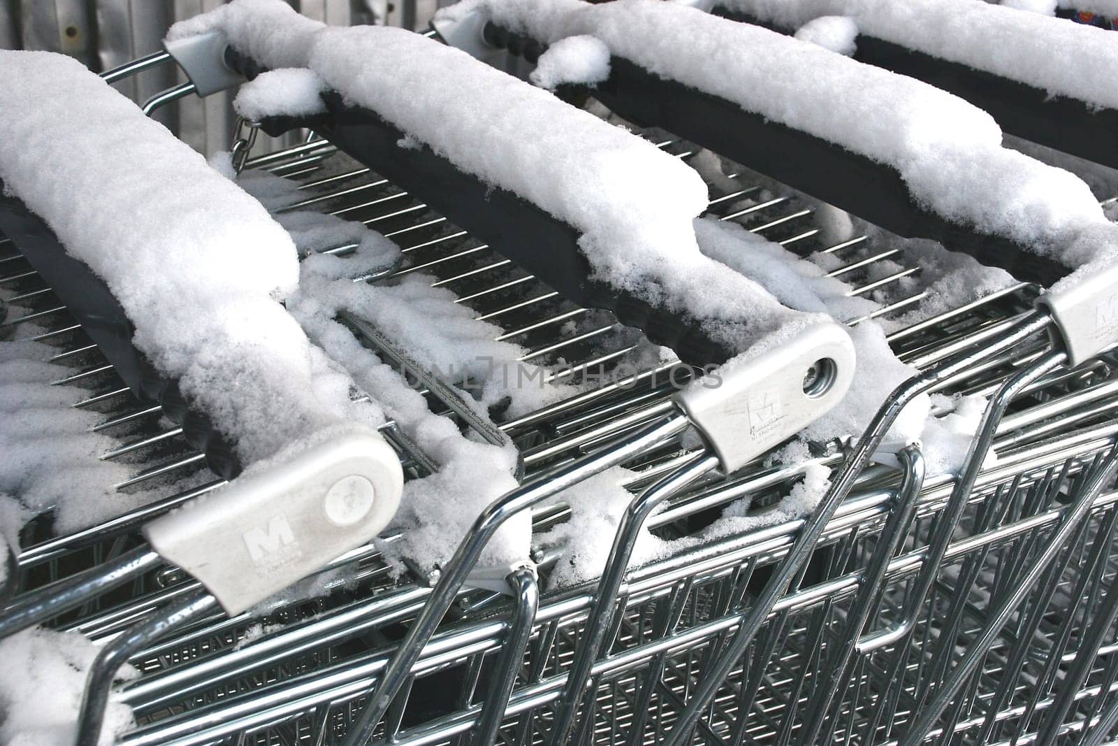 Snowfall on shopping carts . . .  gives cold,wet fingers . . .