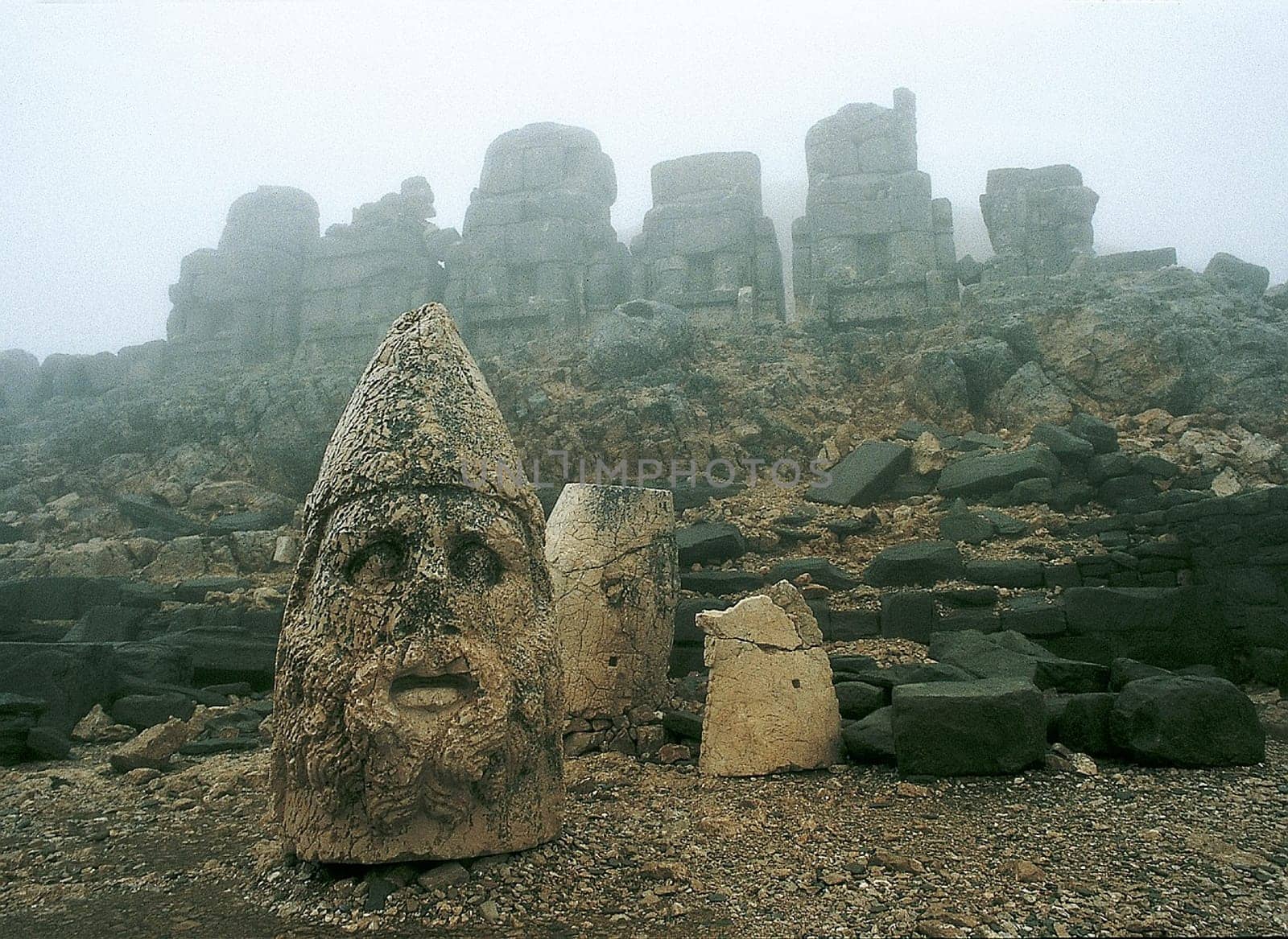 The artificially raised "burial mound"" of Anthiochos I on the 3000m high  Nemrut Dag in Eastern Anatolia,has a diameter of 150m and an altitude of 50m. The five cult figures,originally up to 9m high,embody Greek UN"