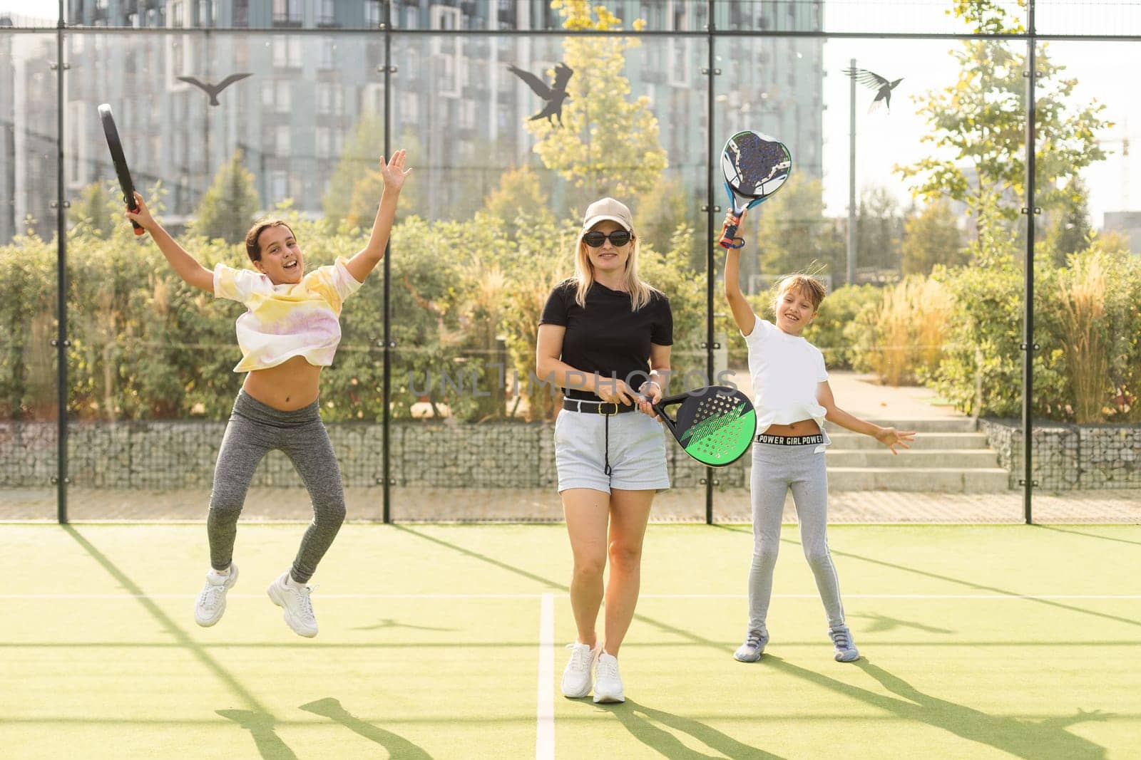 Active young woman practicing Padel Tennis with group of players in the tennis court outdoors. High quality photo