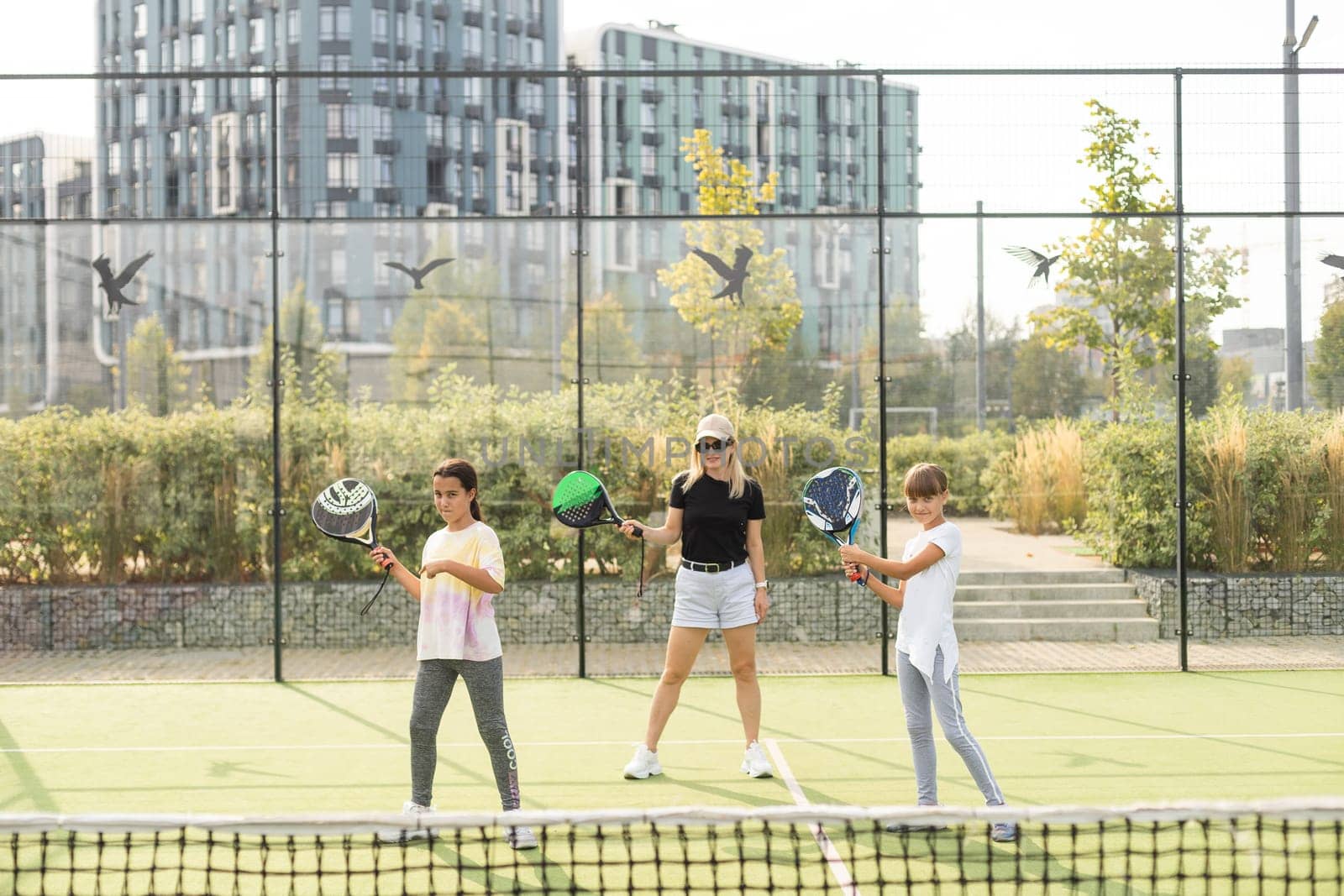 mother and daughters playing padel outdoor. High quality photo