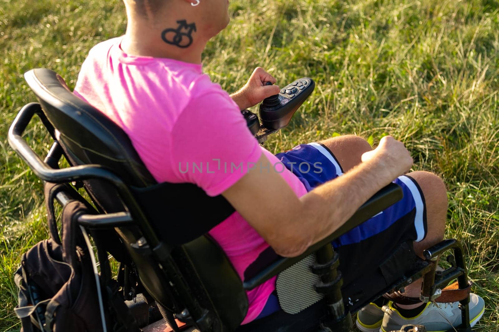 Homoxesual disabled man using joystick in electric wheelchair