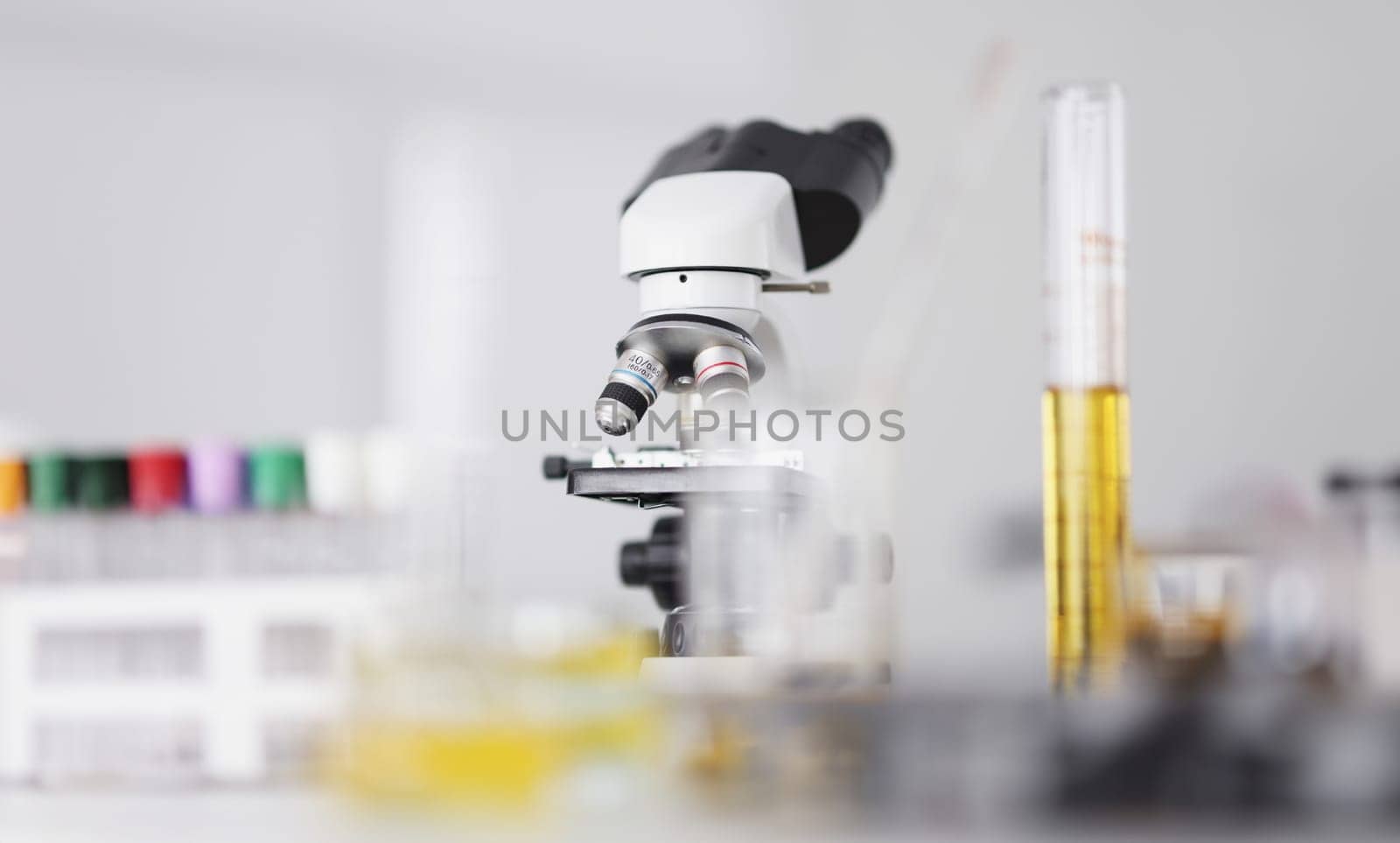 There is microscope and test tube with yellow liquid in laboratory. Development of new types of products concept