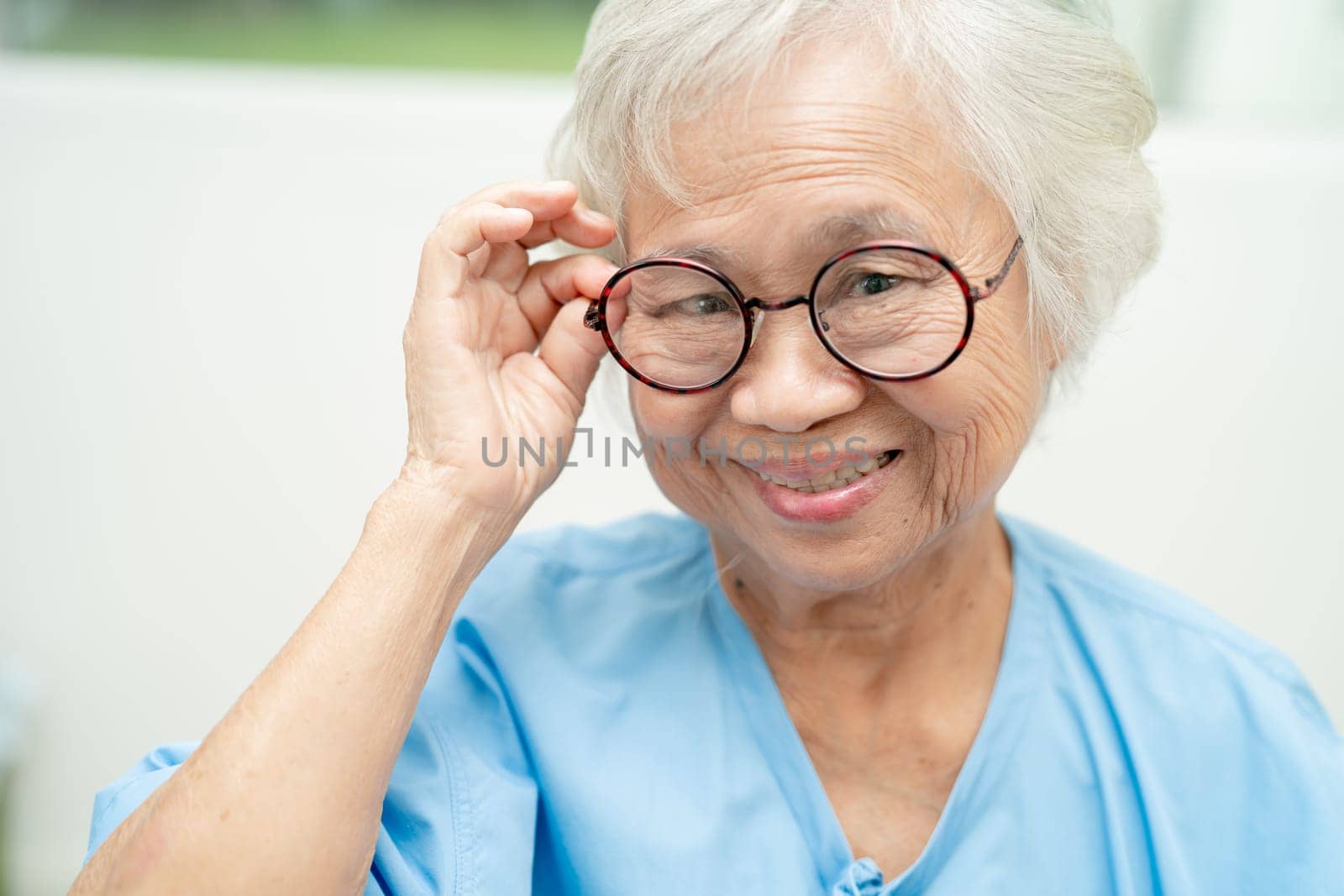 Asian senior woman wearing eyeglasses or vision glasses at home care service. by pamai