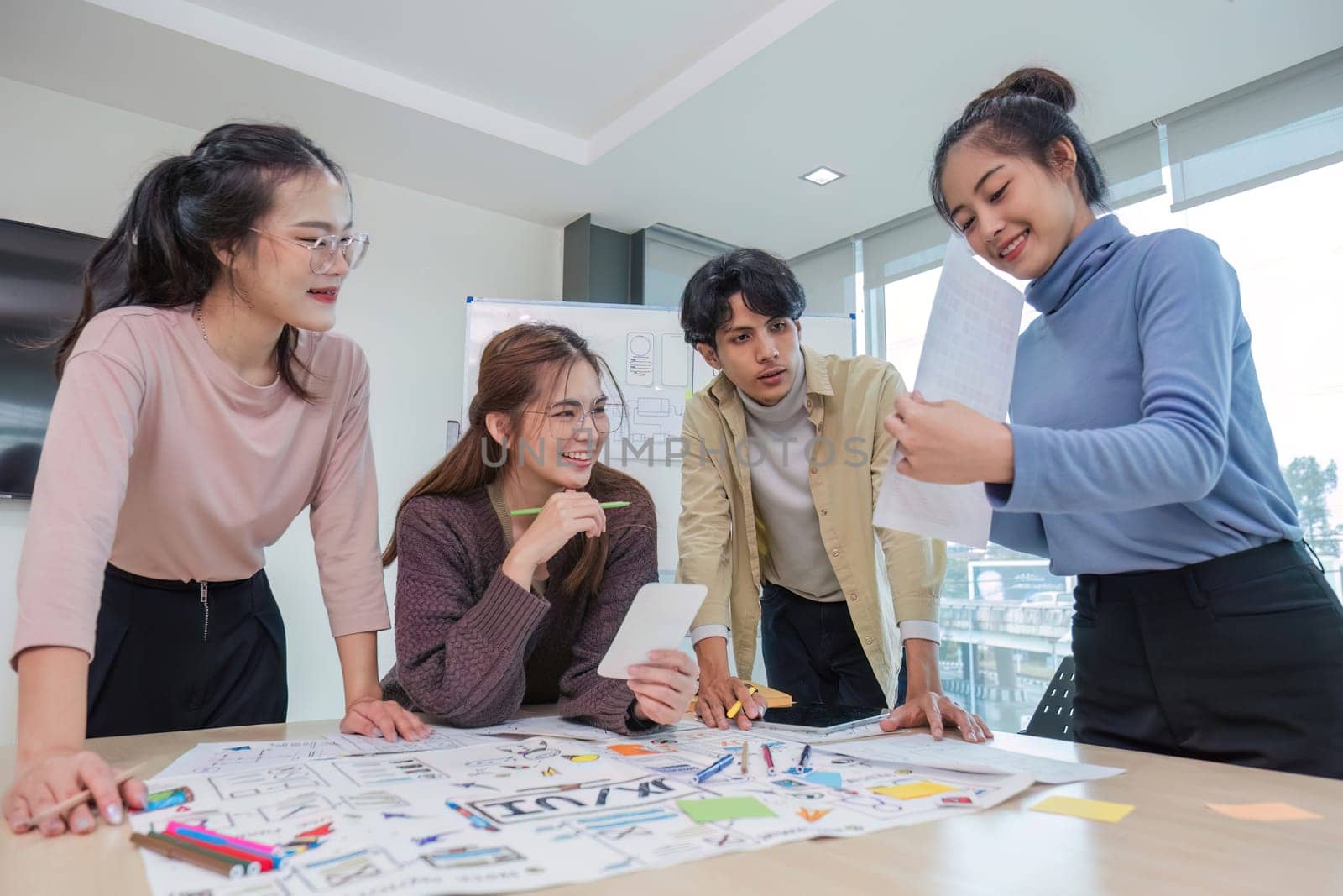 Asian office team brainstorming, plan for solution idea, Group of asian creative teamwork and woman leader at business meeting for developing mobile phone app, ux, ui start up, small business.