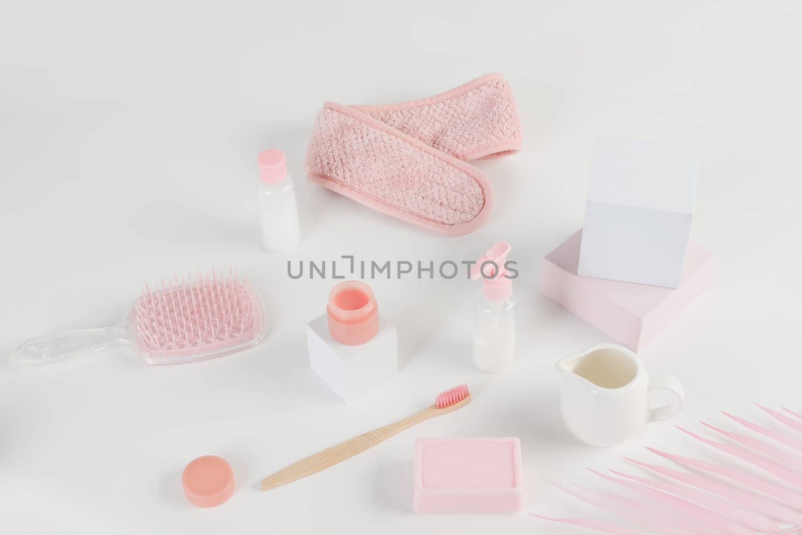 Skincare routine. Pink Women skincare products on white background. Soap, facial foam, cleansing, serum, cream lotion, toothbrush, lipstick. Beauty concept. Natural cosmetic pink flat lay top view.