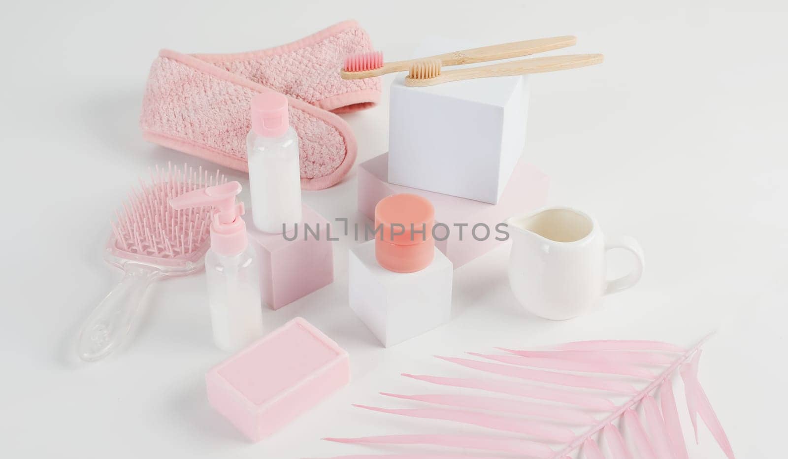 Skincare routine. Pink Women skincare products on white background. Soap, facial foam, cleansing, serum, cream lotion, toothbrush, lipstick. Beauty concept. Natural cosmetic pink flat lay top view.