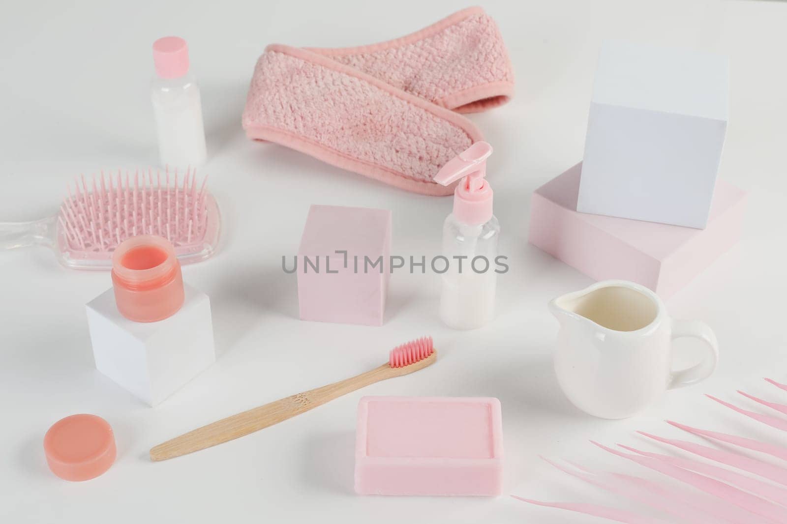 Skincare routine. Pink Women skincare products on white background. Soap, facial foam, cleansing, serum, cream lotion, toothbrush, lipstick. Beauty concept. Natural cosmetic pink flat lay top view.