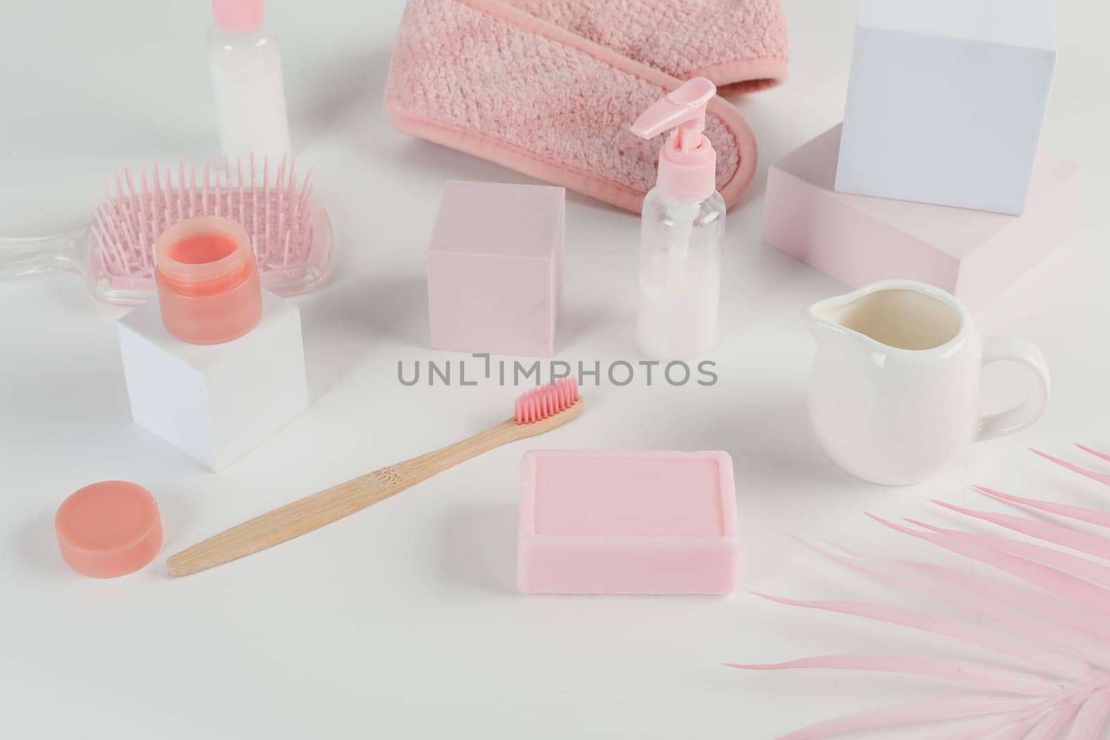 Skincare routine. Pink Women skincare products on white background. Soap, facial foam, cleansing, serum, cream lotion, toothbrush, lipstick. Beauty concept. Natural cosmetic pink flat lay top view.