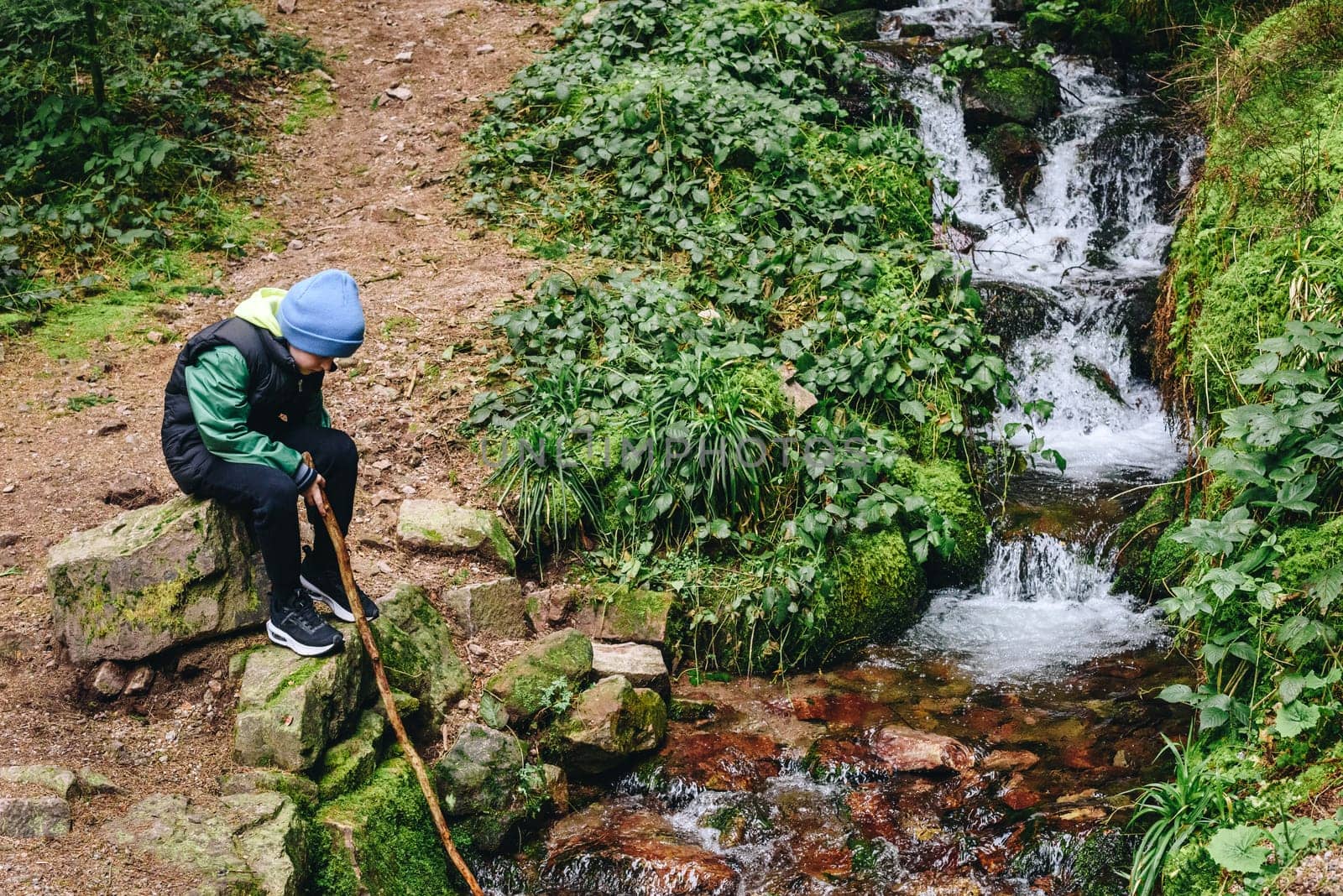 Children hiking in Alps mountains crossing river. Kids play in water at mountain in Austria. Spring family vacation. Little boy on hike trail. Outdoor fun. Active recreation with children. by Andrii_Ko