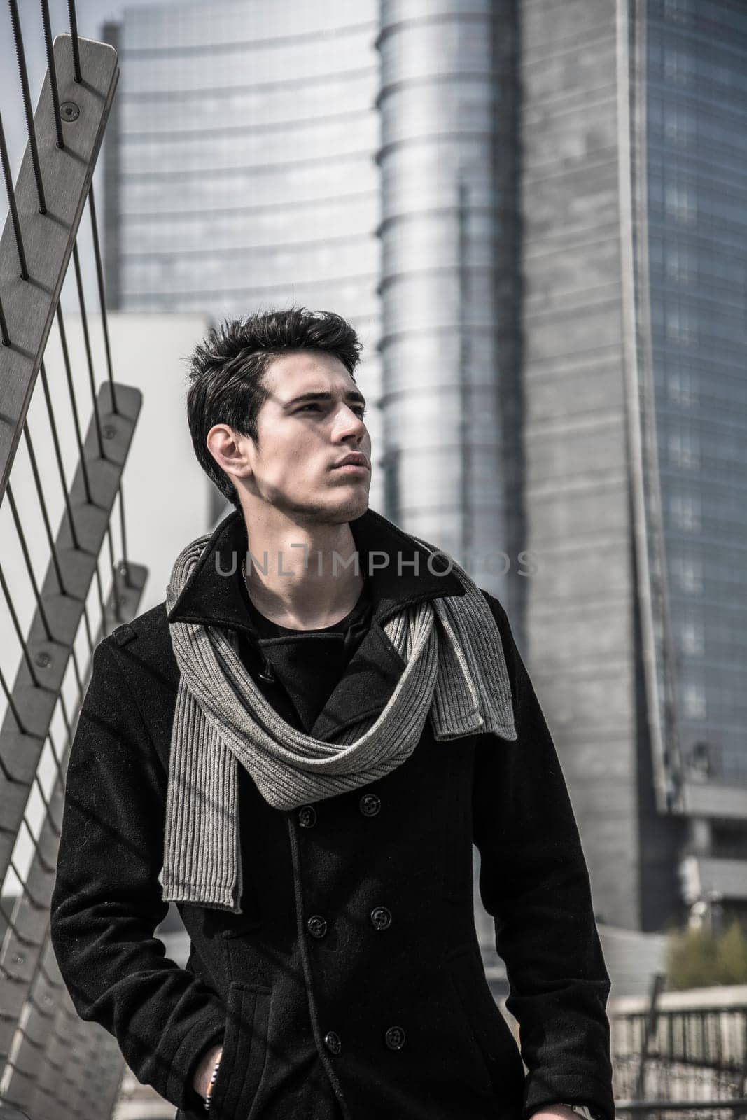 A man standing in front of a tall building. Photo of a man standing in front of a towering skyscraper