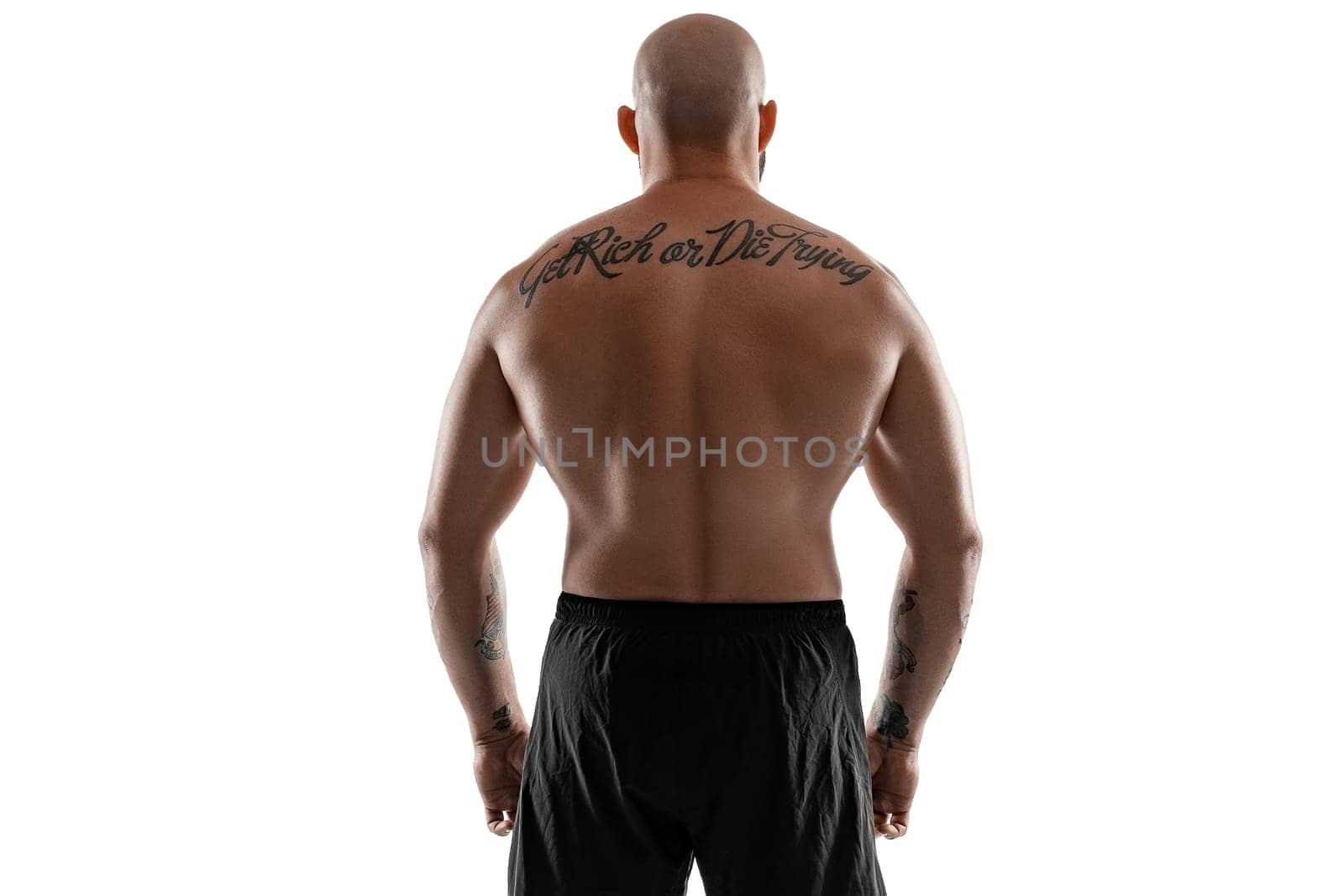 Athletic bald, tattooed man in black shorts is posing isolated on white background. Close-up portrait. by nazarovsergey