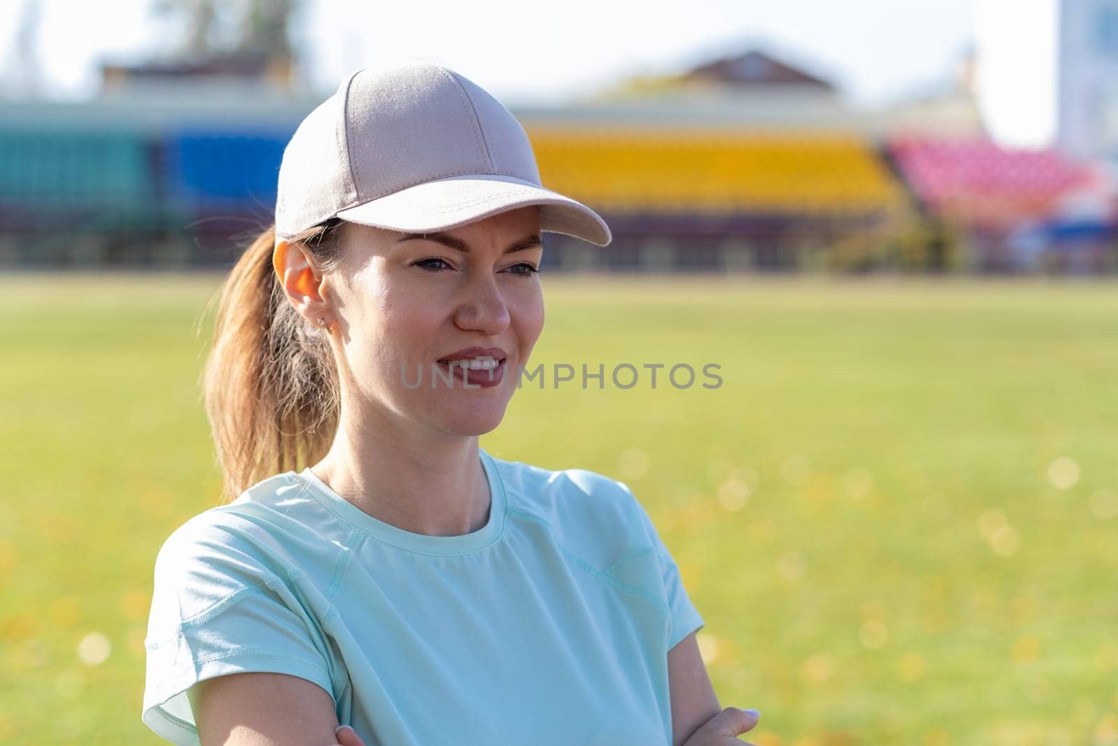 A young beautiful woman in sportswear plays sports at a local stadium by AnatoliiFoto