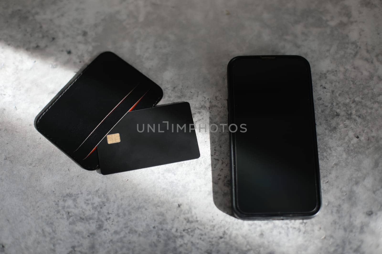 Leather card holder with blank black card mock up isolated. Phone and Black credit card on office table. Flat lay. Premium banking concept. Logo design presentation.