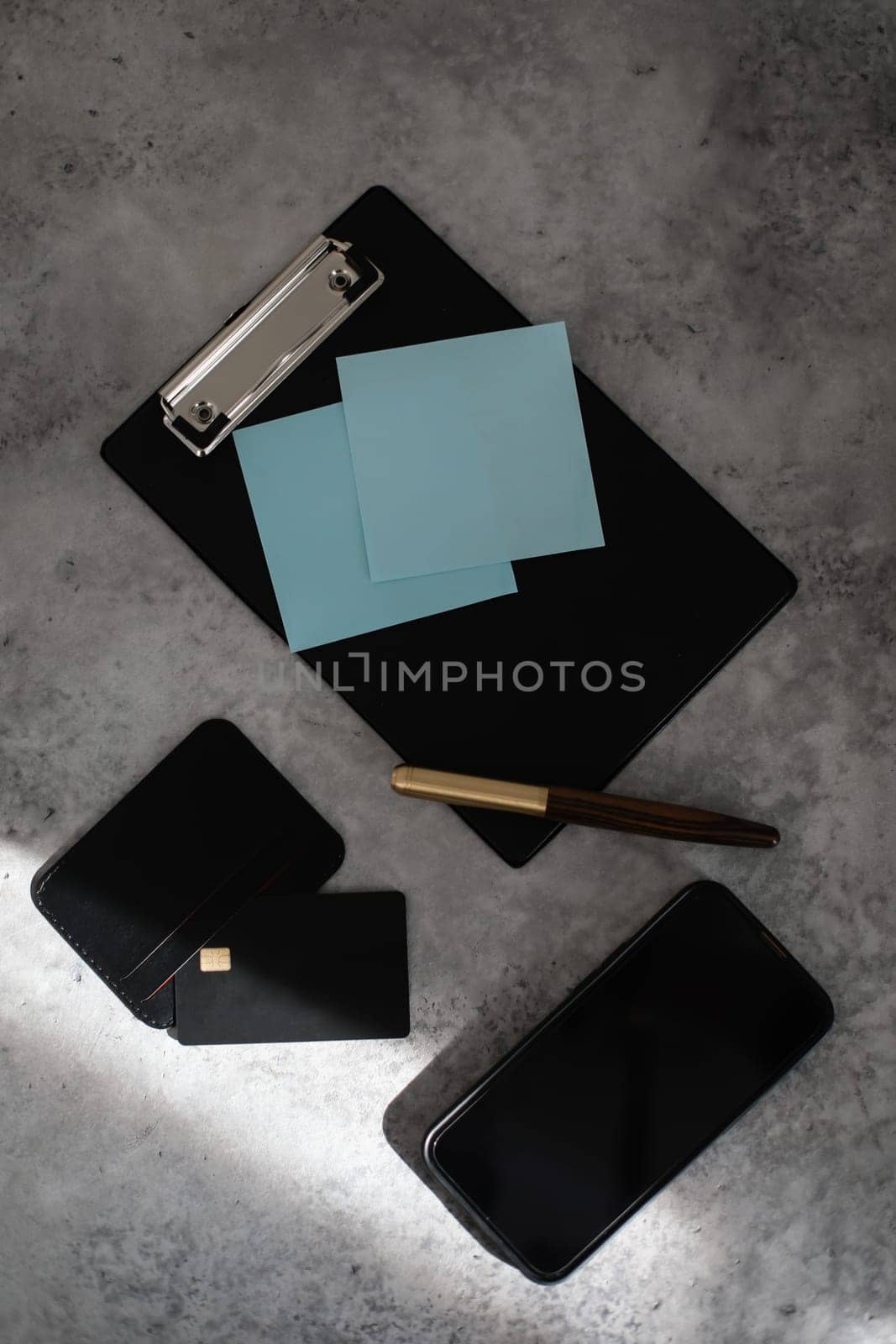 Flatlay of blank screen mobile phone, pen, creadit card, notepad on neutral grey background. Aesthetic home office desk workspace. business, work, blog template with mockup space. Flat lay, top view