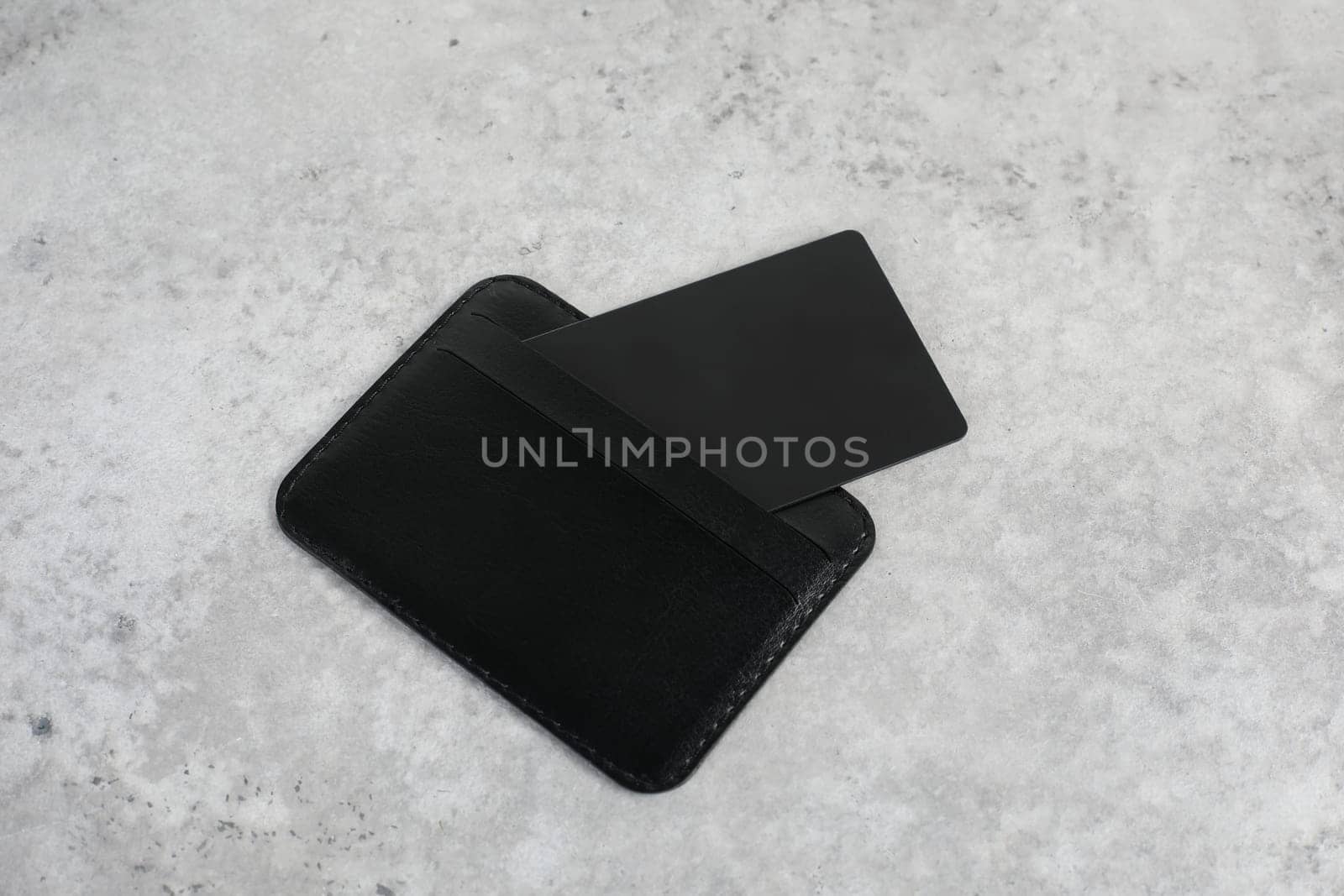 Leather card holder with blank black card mock up isolated. Black credit card on office table. Flat lay. Premium banking concept. Logo design presentation. by paralisart