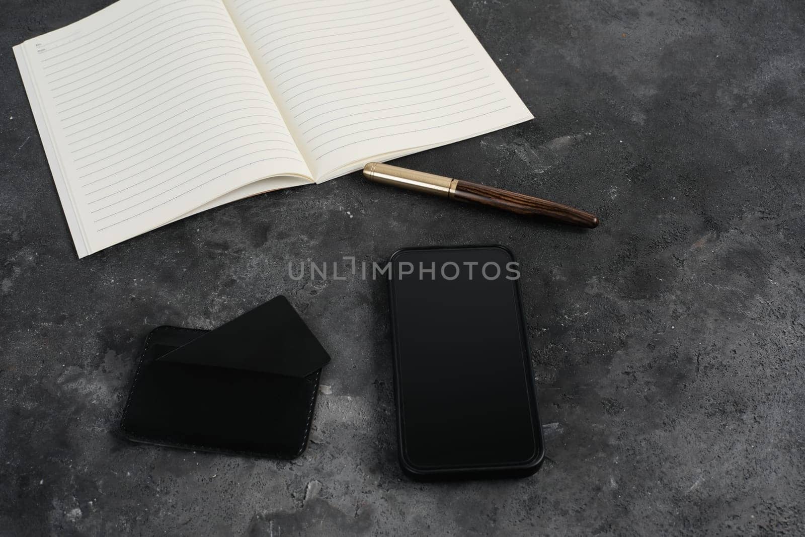 Flatlay of blank screen mobile phone, pen, creadit card, notepad on neutral grey background. Aesthetic home office desk workspace. business, work, blog template with mockup space. Flat lay, top view