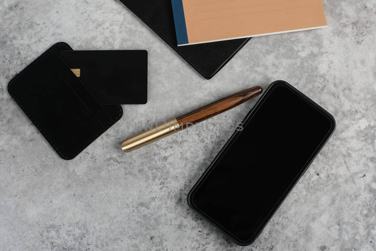 Flatlay of blank screen mobile phone, pen, creadit card, notepad on neutral grey background. Aesthetic home office desk workspace. business, work, blog template with mockup space. Flat lay, top view
