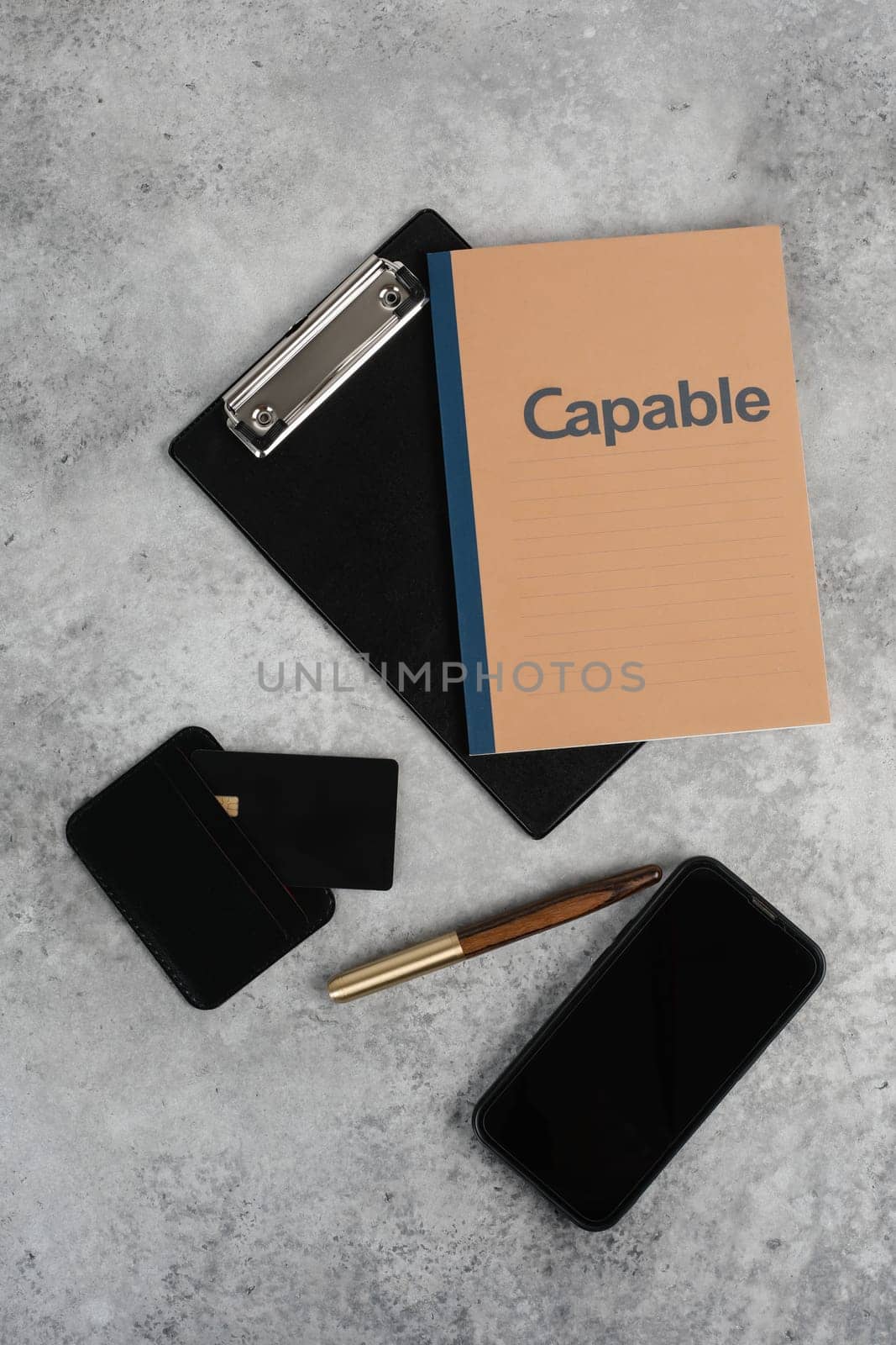 Stylish minimalist mockup with credit card, planner, phone and pen on grey background with copyspace. Aesthetic minimal office desk table mockup. Flat lay, top view.