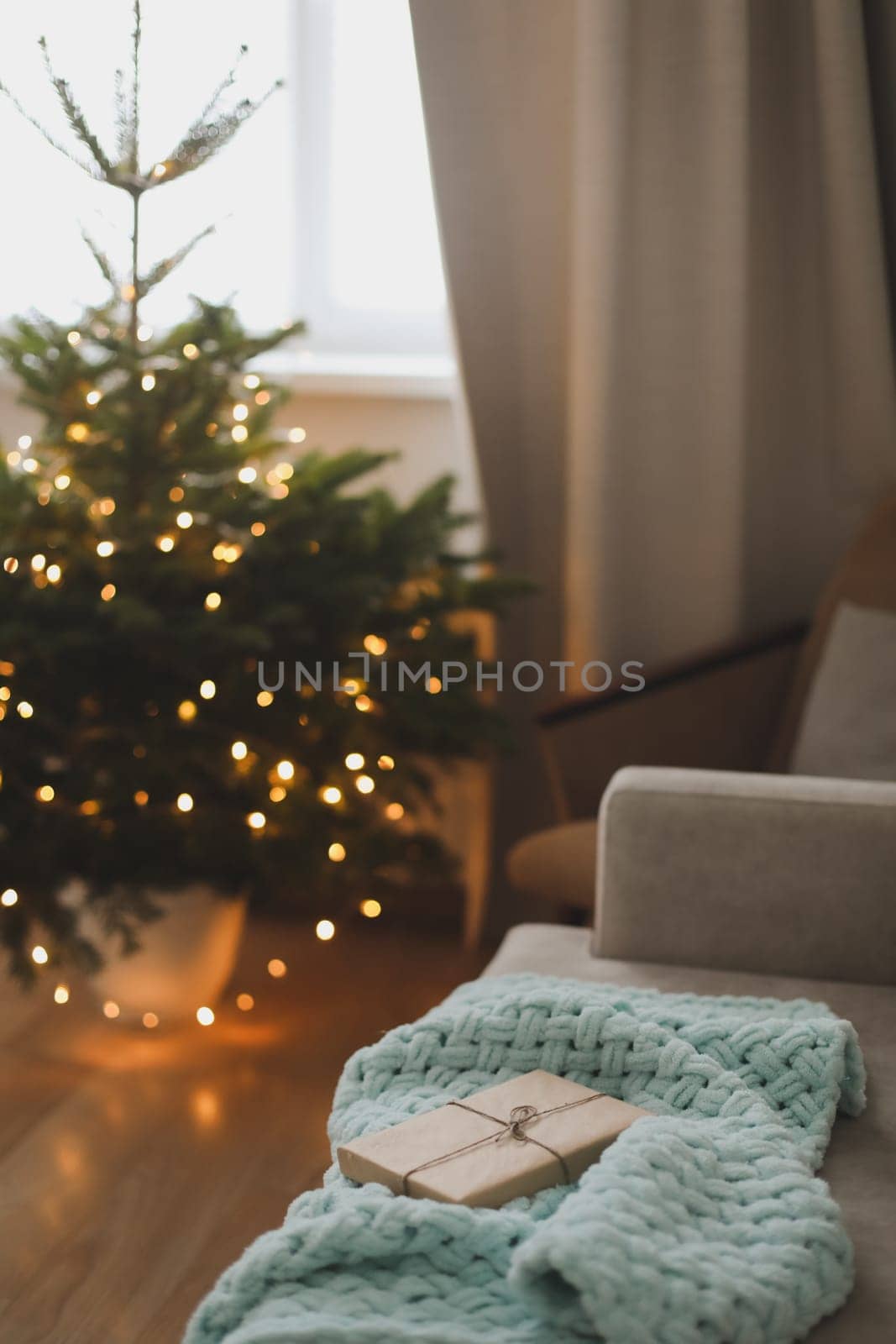 Christmas gift wrapped in craft paper under a tree. New Year card.