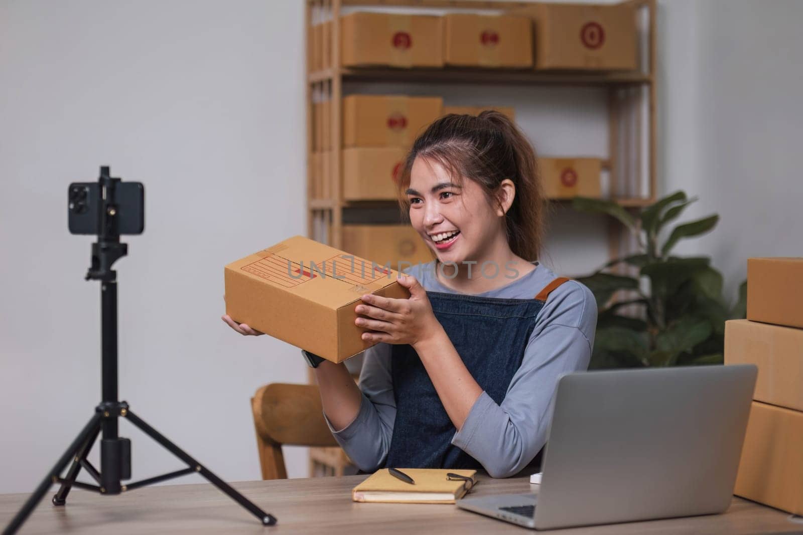 Asian blogger review products and video camera on her phone, sell them online, and showcase her products online on social media. ecommerce business live streaming vlog new normal concept.