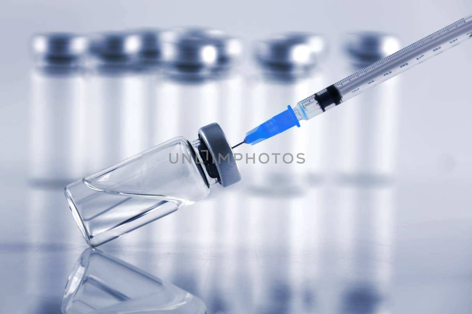 A medical syringe and vaccine ampule bottles