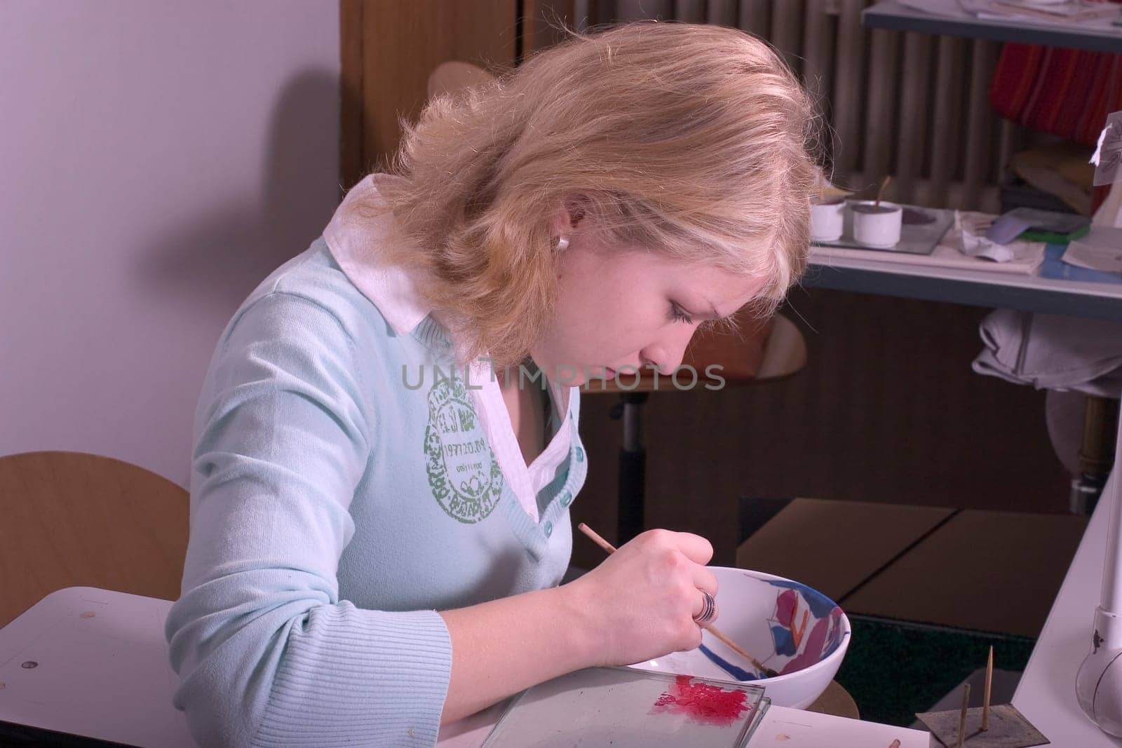 College-teacher painting a porcelain bowl