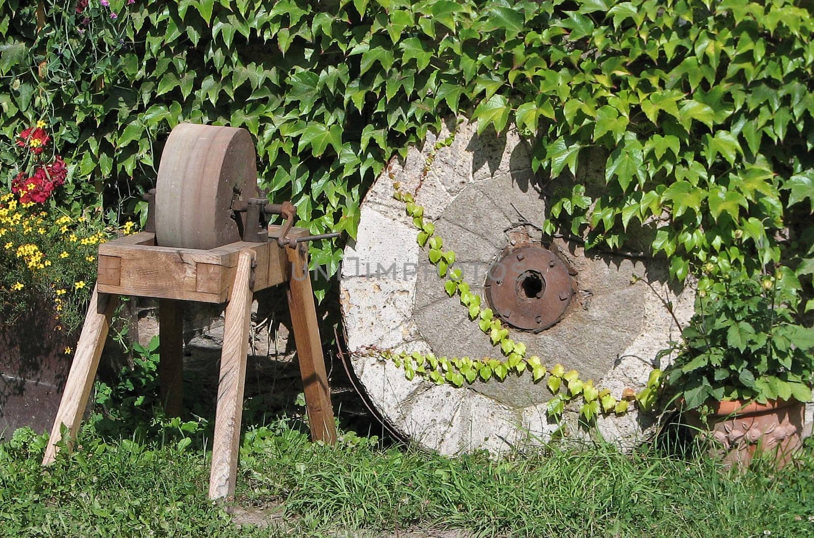 Grinding machine next to old millstone