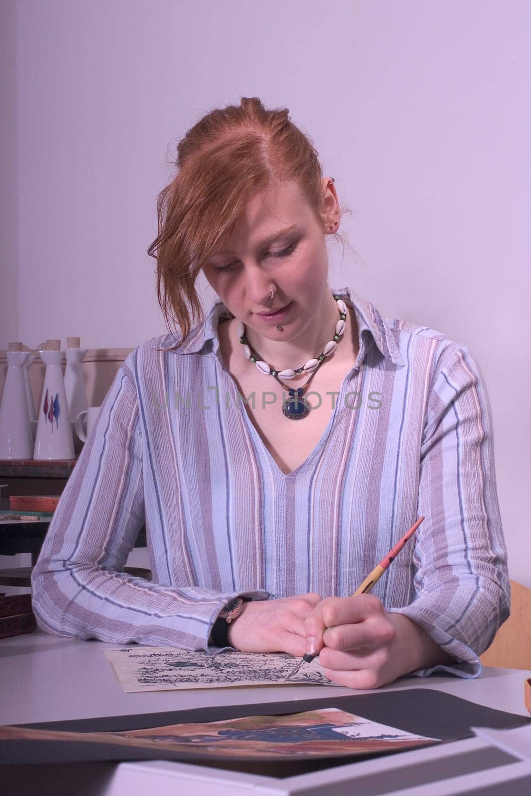 High school student painting and writing a kalligaphic work.