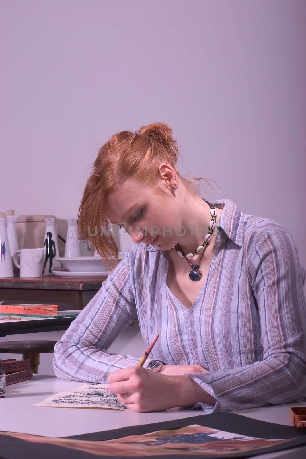 High school student painting and writing a kalligaphic work.