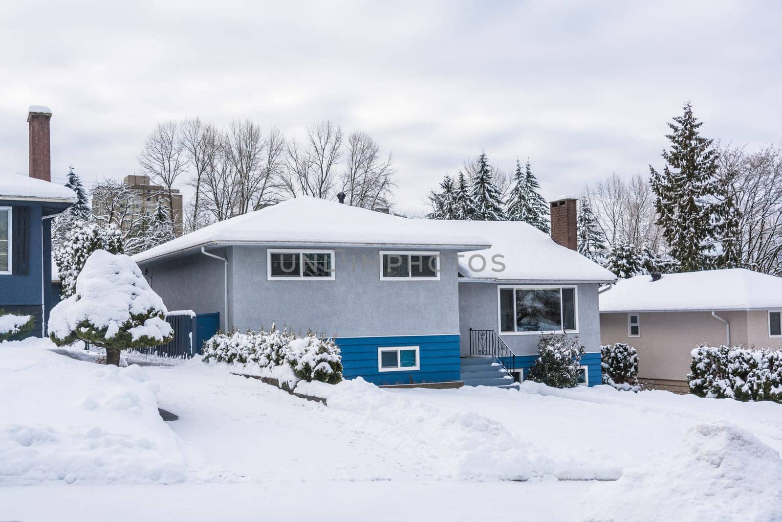 Family residential house with front yard in snow. North American house on winter cloudy day