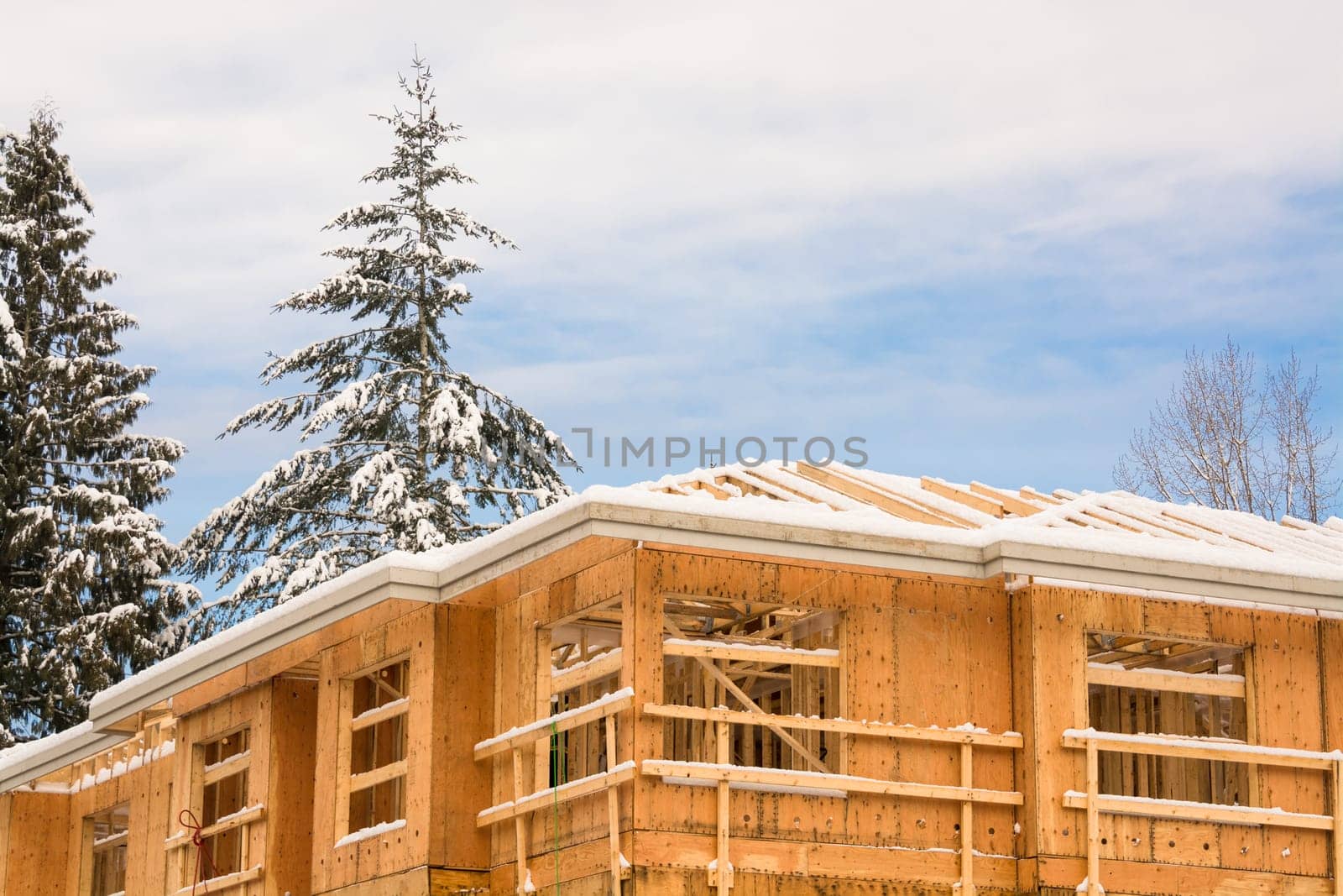 Fragment of townhome complex under construction on winter time. by Imagenet
