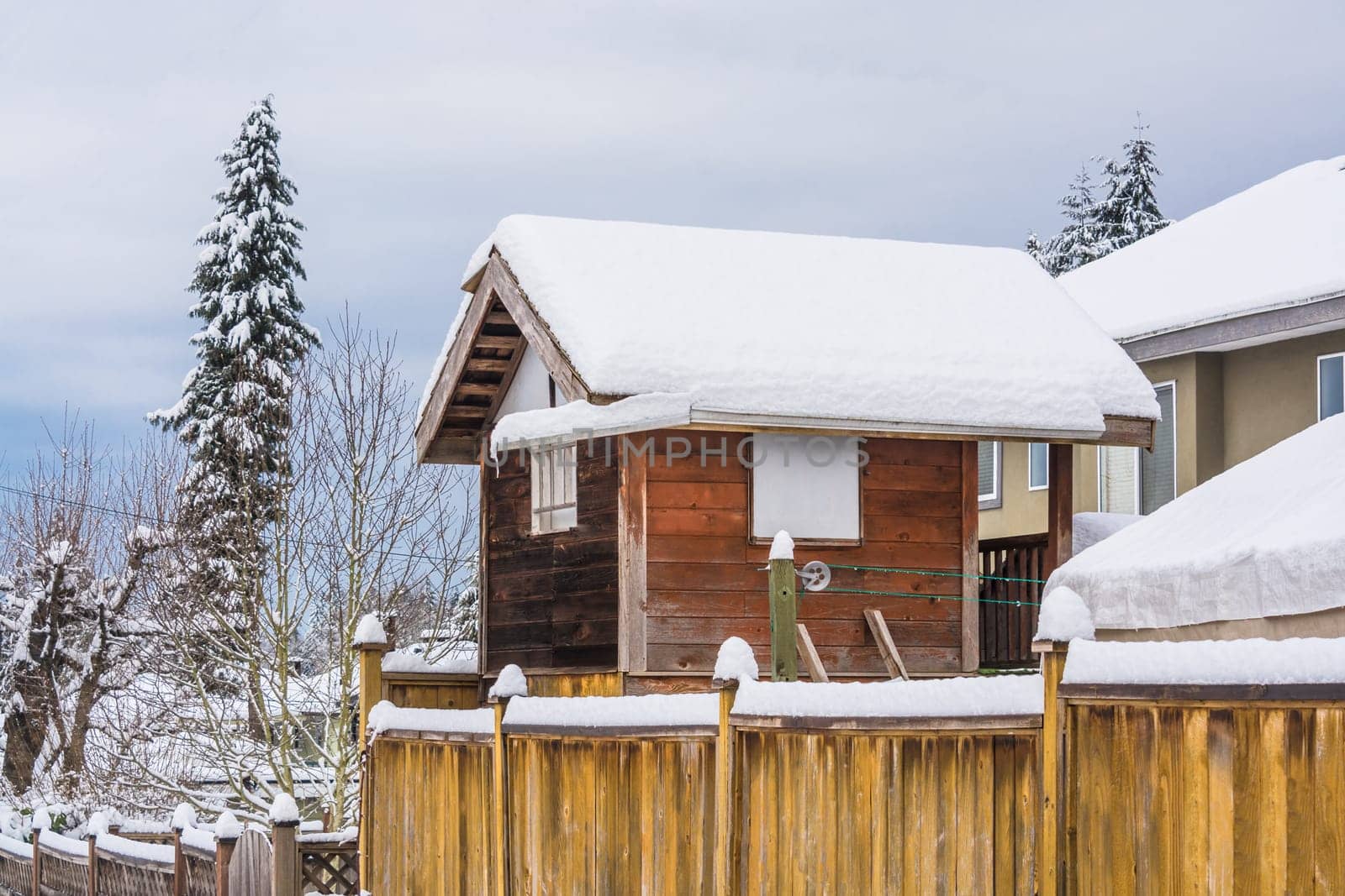 Storage sheld on back yard in snow on winter day