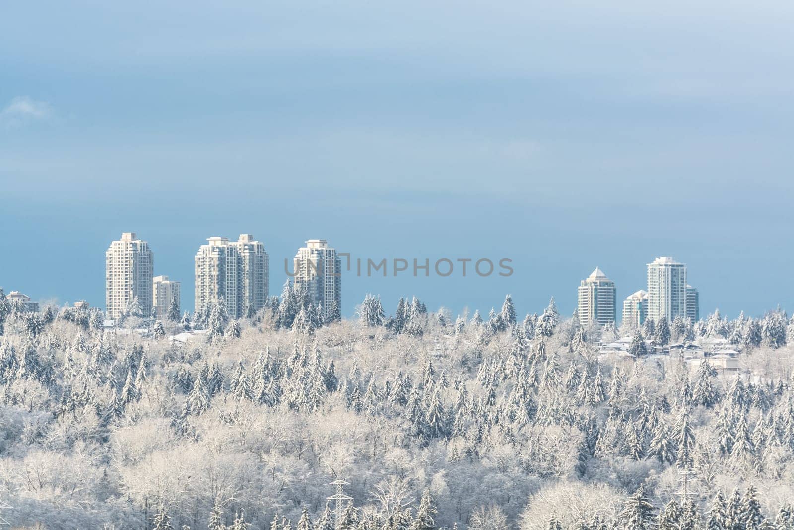 City in the snow. Residential tower buildings on bright winter day in Canada. by Imagenet