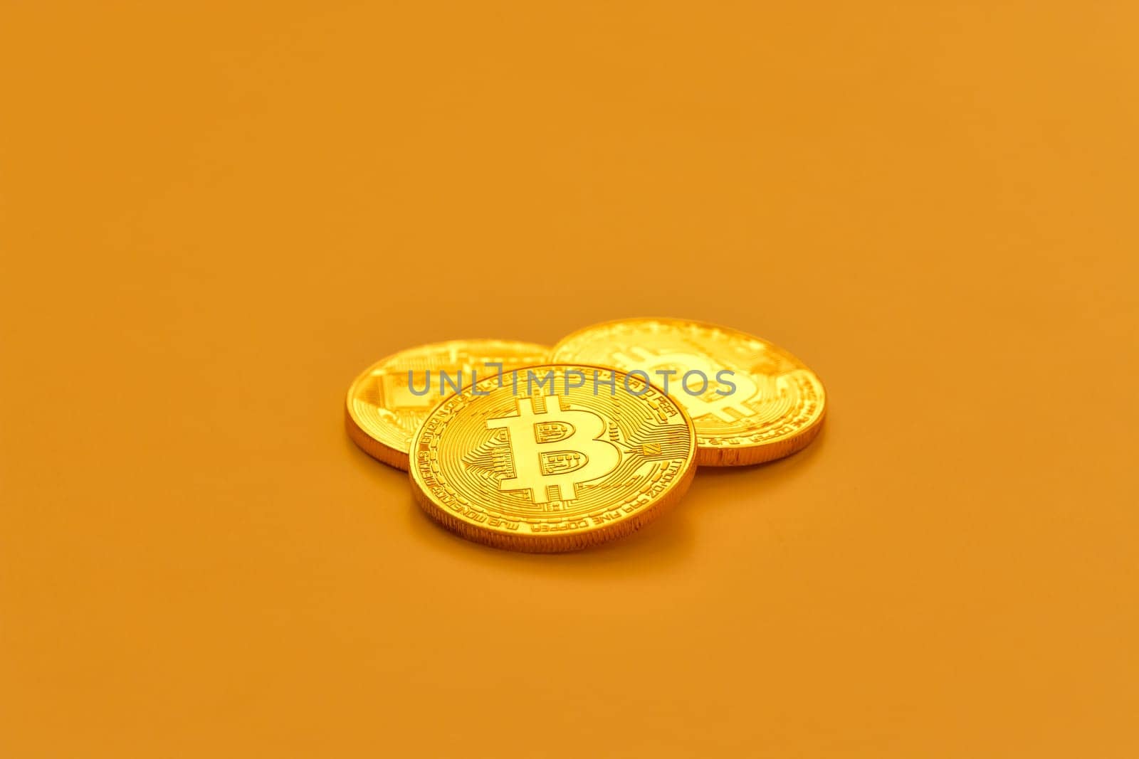 Three yellow bitcoin beans laying on flat surface. by Imagenet