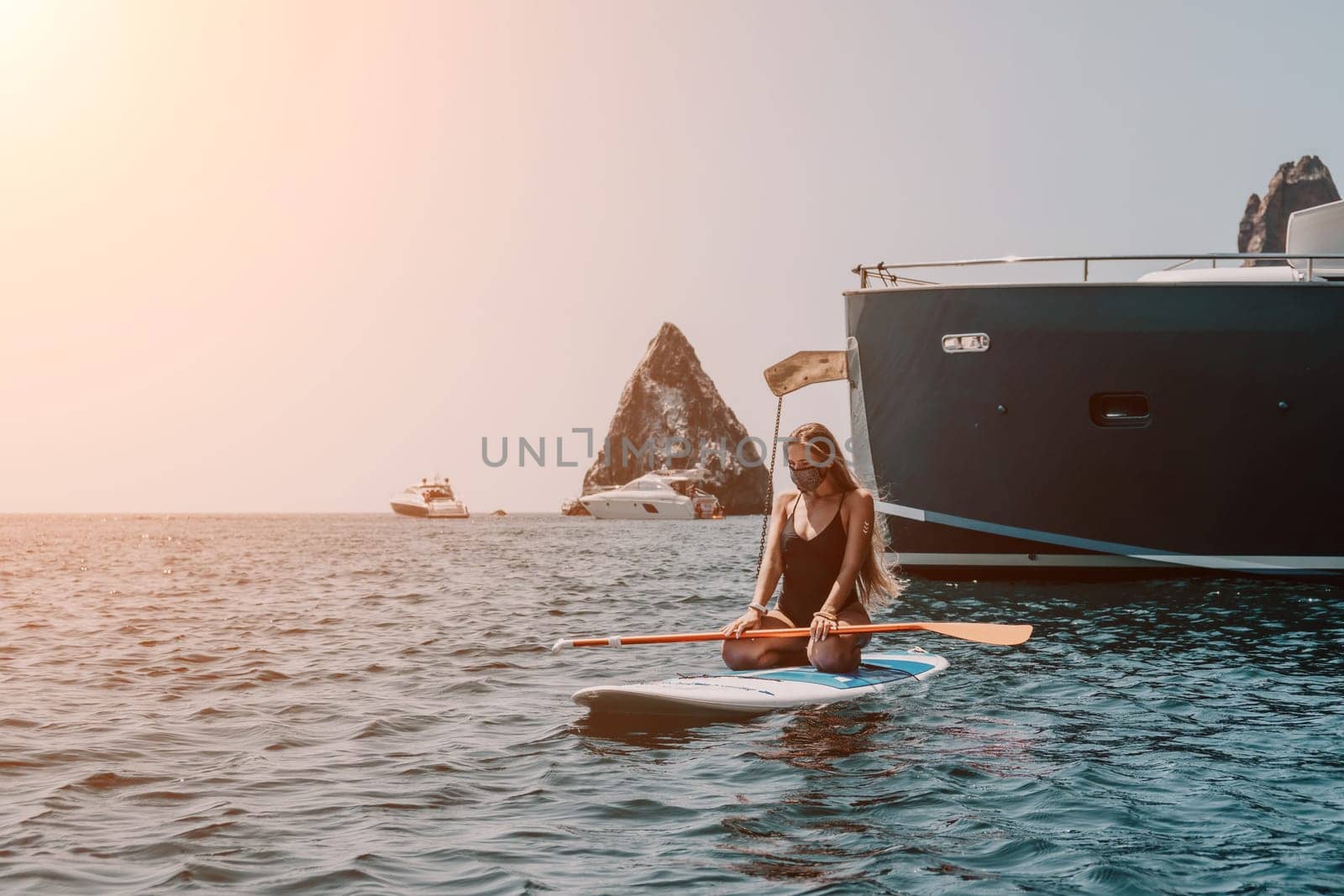 Woman sea sup. Close up portrait of happy young caucasian woman with long hair looking at camera and smiling. Cute woman portrait in bikini posing on sup board in the sea by panophotograph