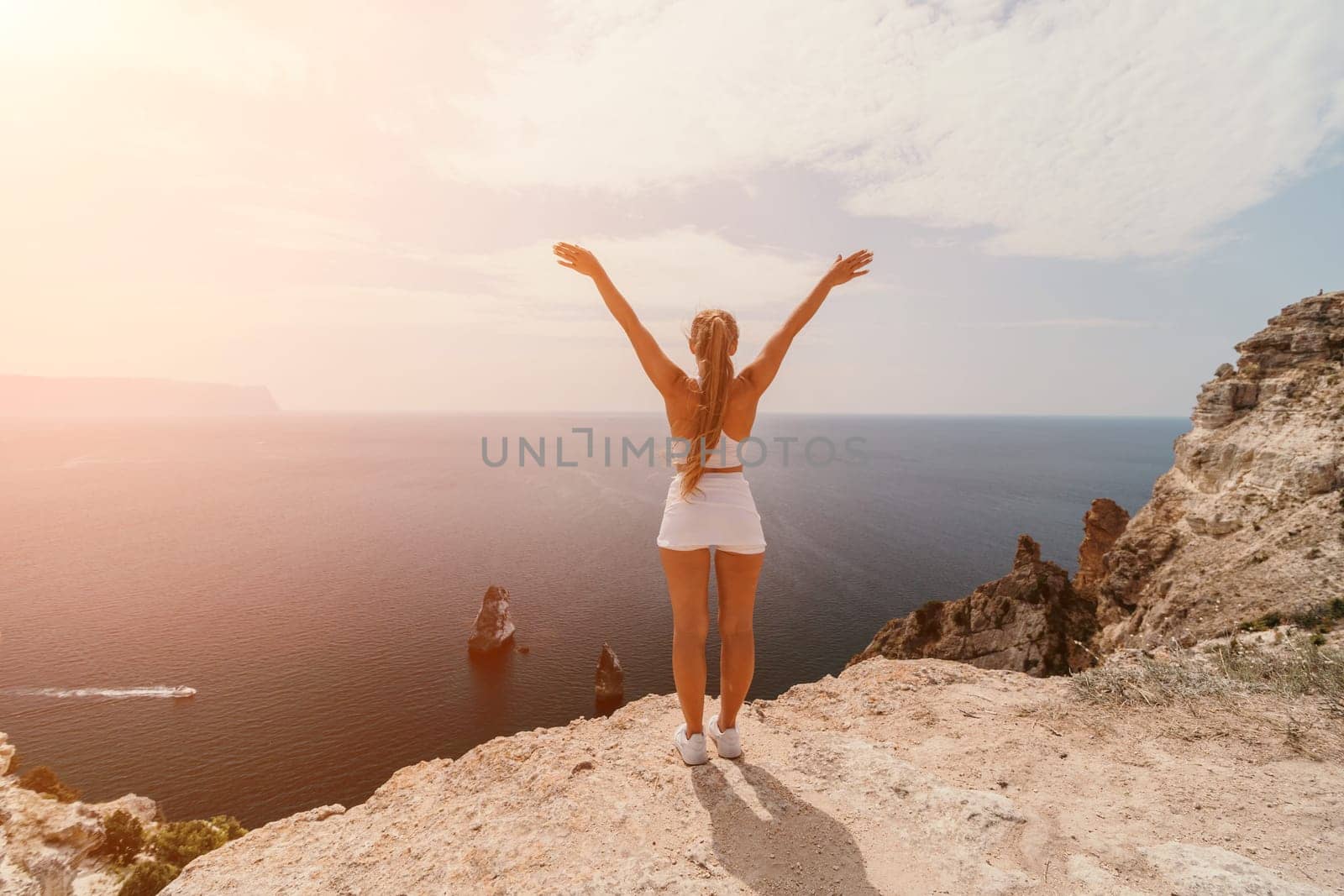 Woman travel sea. Happy tourist in hat enjoy taking picture outdoors for memories. Woman traveler posing on the beach at sea surrounded by volcanic mountains, sharing travel adventure journey