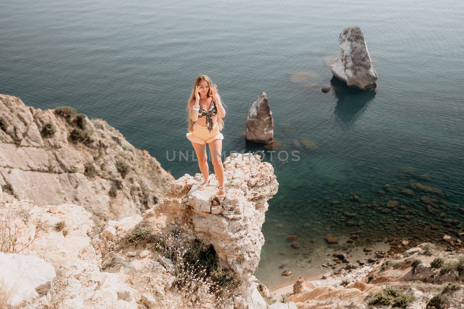 Woman travel sea. Happy tourist enjoy taking picture outdoors for memories. Woman traveler looks at the edge of the cliff on the sea bay of mountains, sharing travel adventure journey by panophotograph