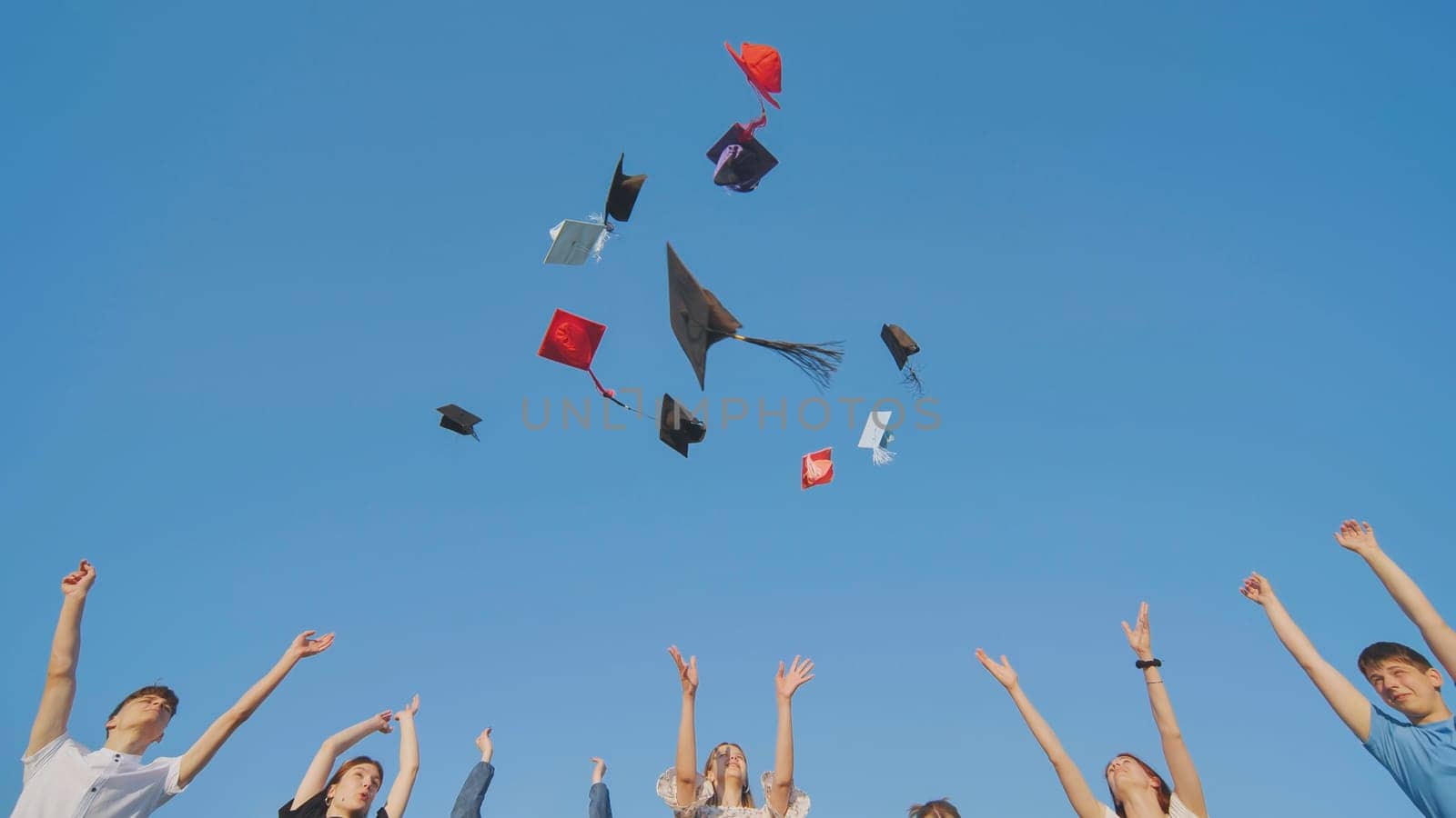 College graduates throw colorful hats up in the air