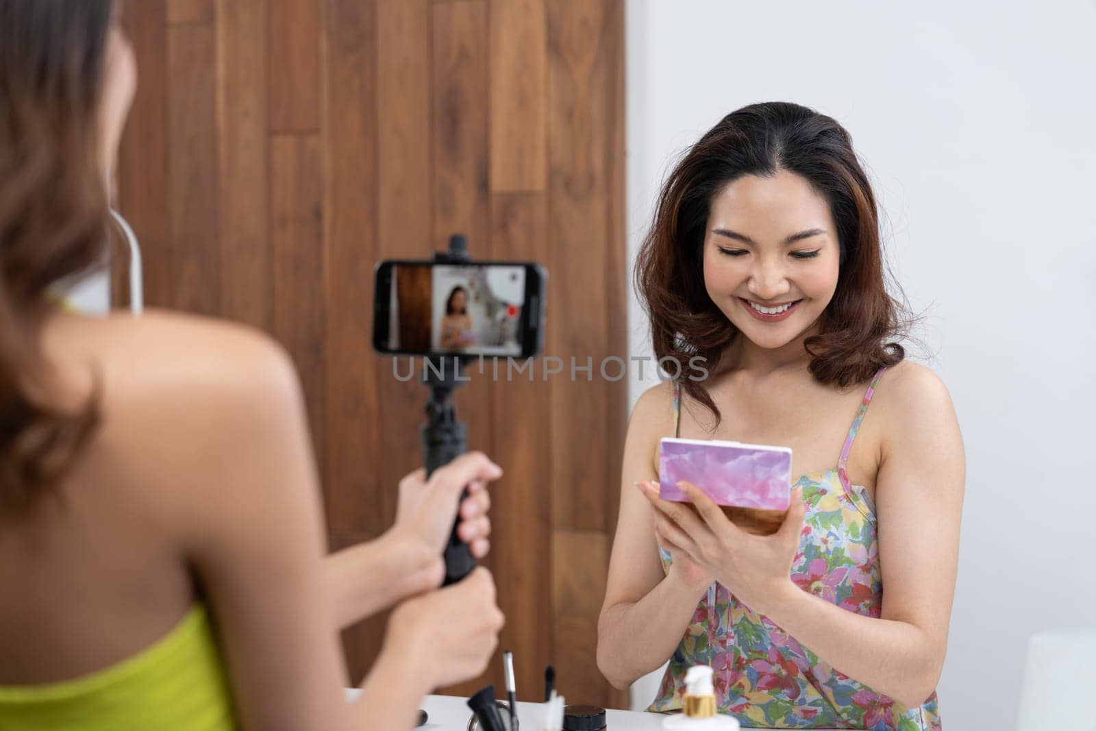 Woman influencer shoot live streaming vlog video review makeup uttermost social media or blog. Happy young girl with cosmetics studio lighting for marketing recording session broadcasting online.